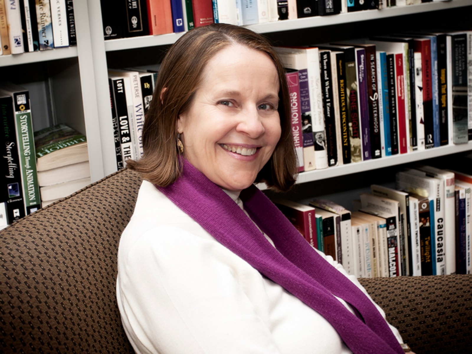 Portrait of DigiPen humanities professor Claire Joly in front of bookshelves in the campus library
