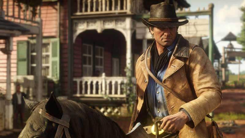Red Dead Redemption 2’s protagonist Arthur Morgan rides into town on his horse.