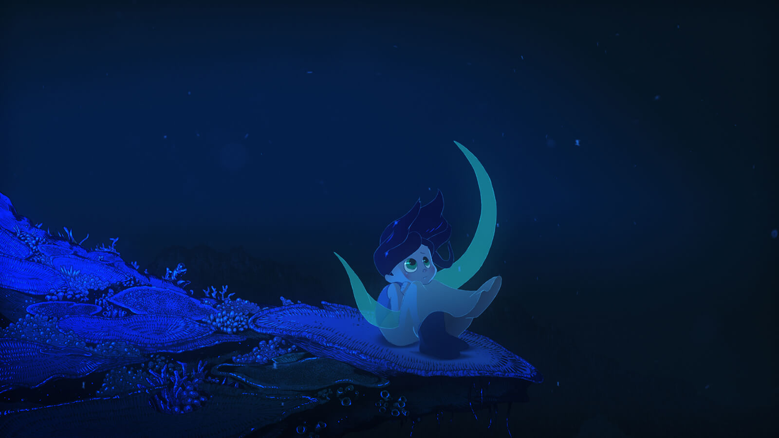 A girl sits on top of a flat coral seat underwater. She looks up into the dark sea.