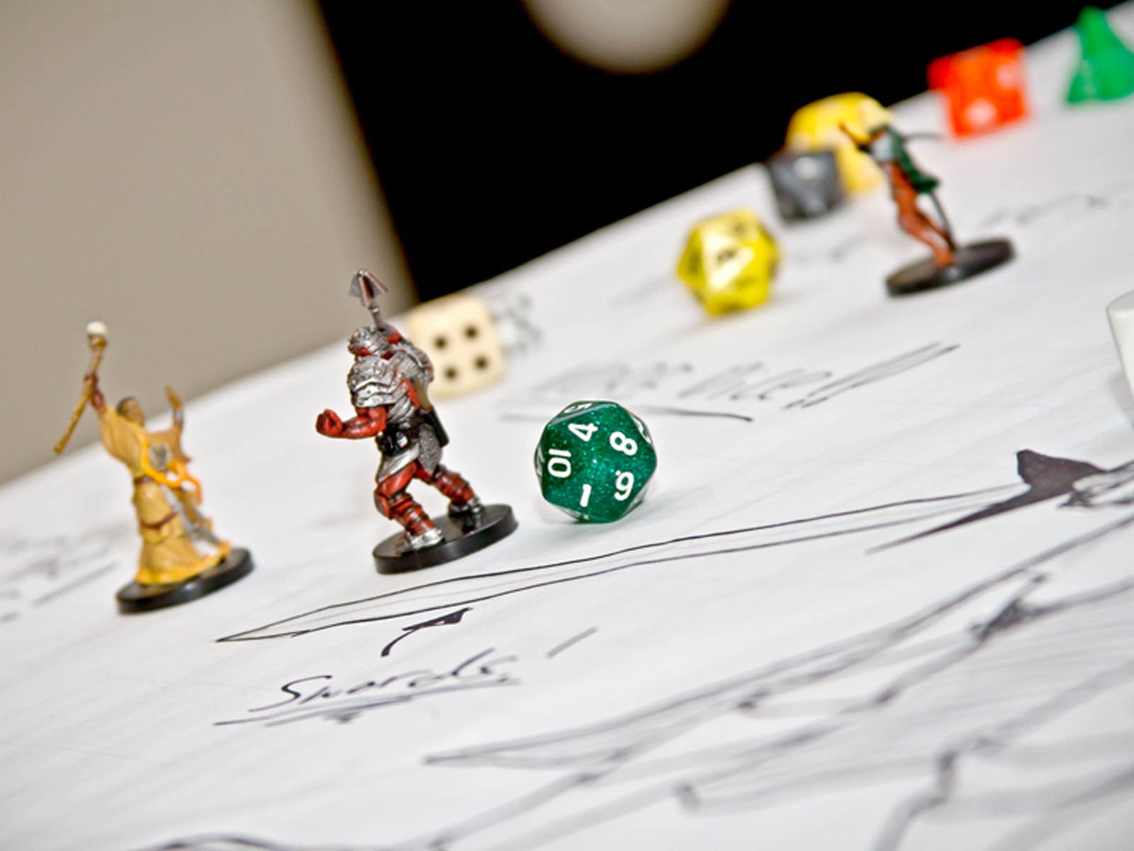 Close-up of board game figurines and 10-sided die