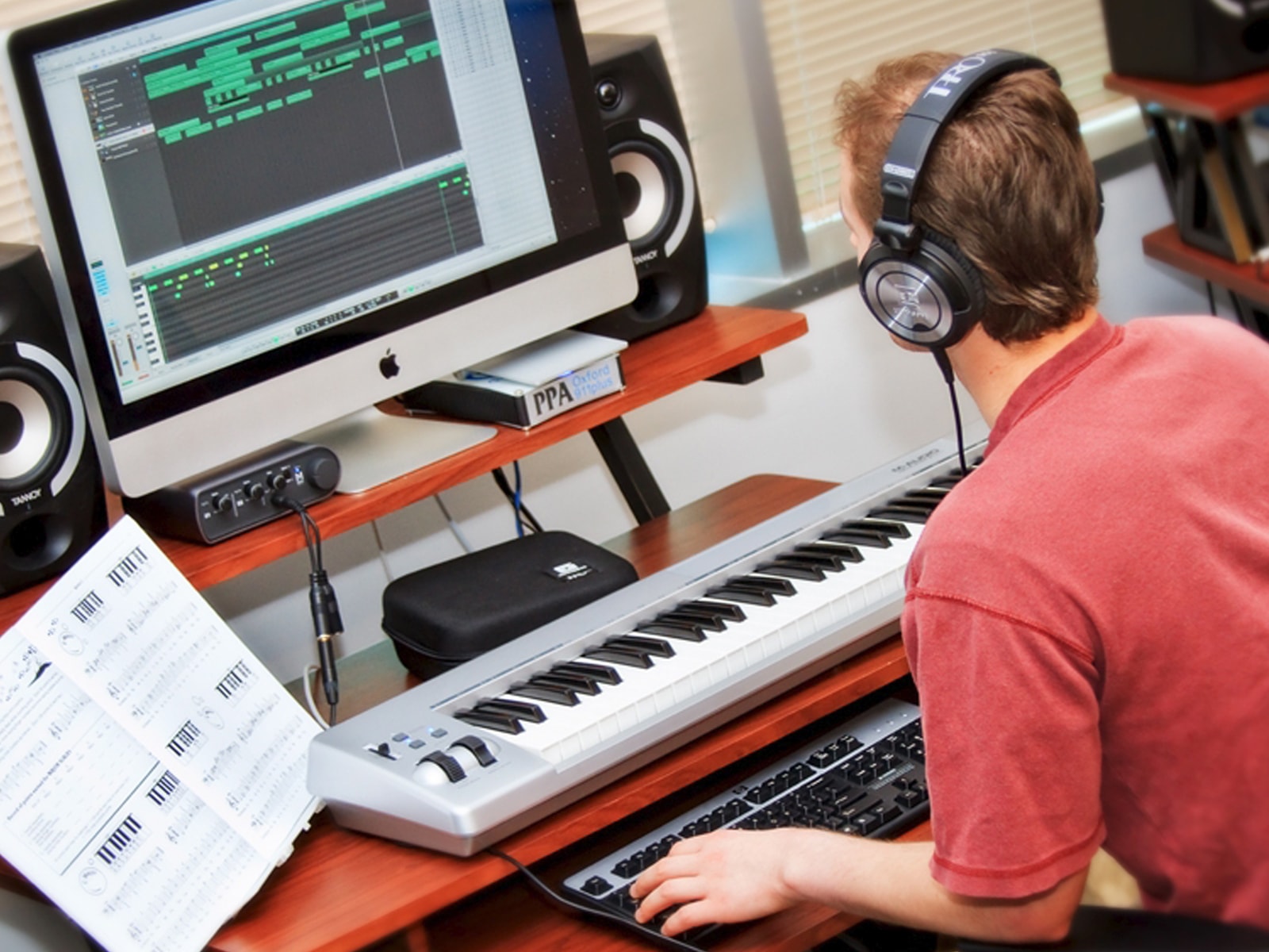 DigiPen sound design student composing music with a computer and a digital piano keyboard