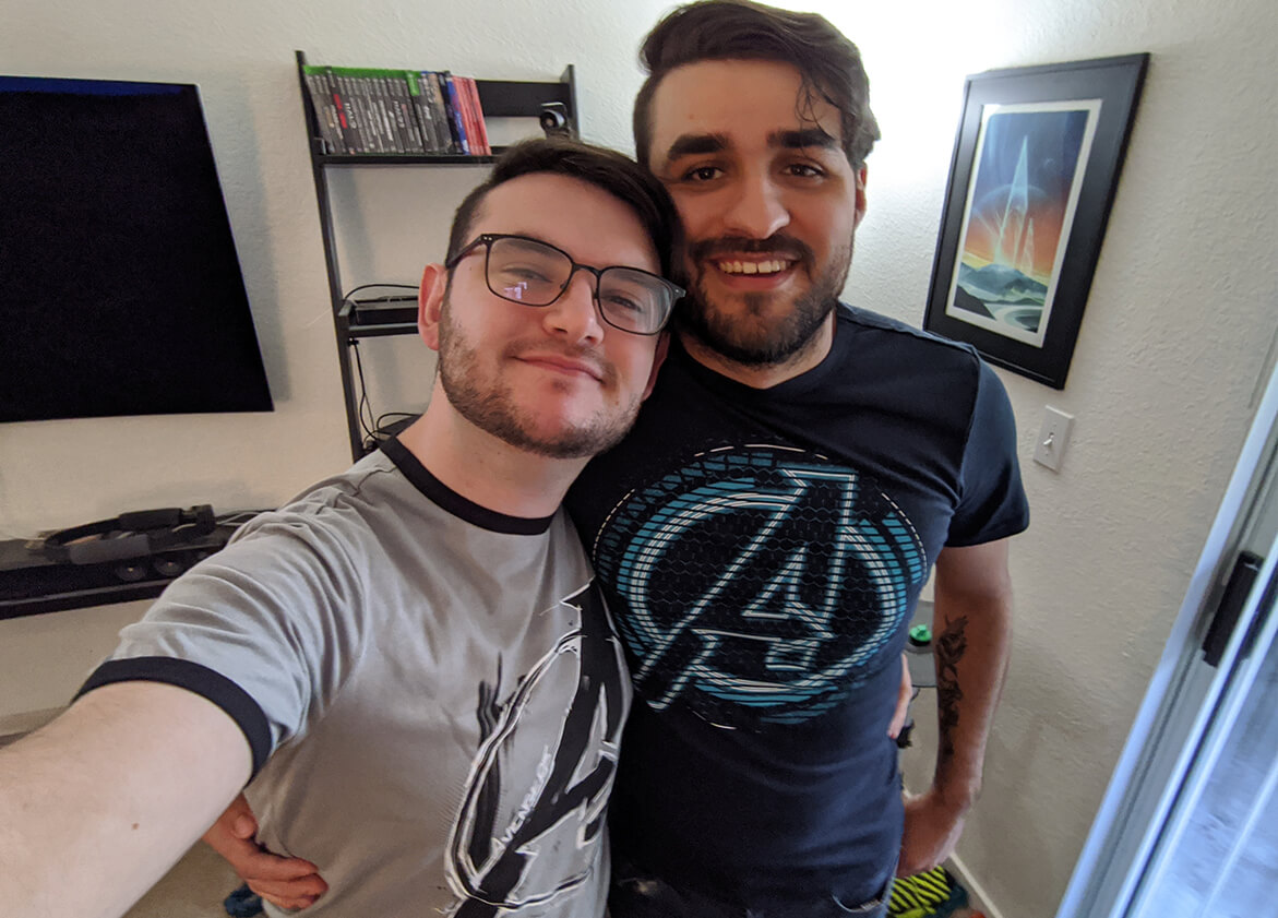 DigiPen alumni and Crystal Dynamics designers Matthew Guido and Chase De La Cruz pose with arms around each other, wearing Avengers shirts