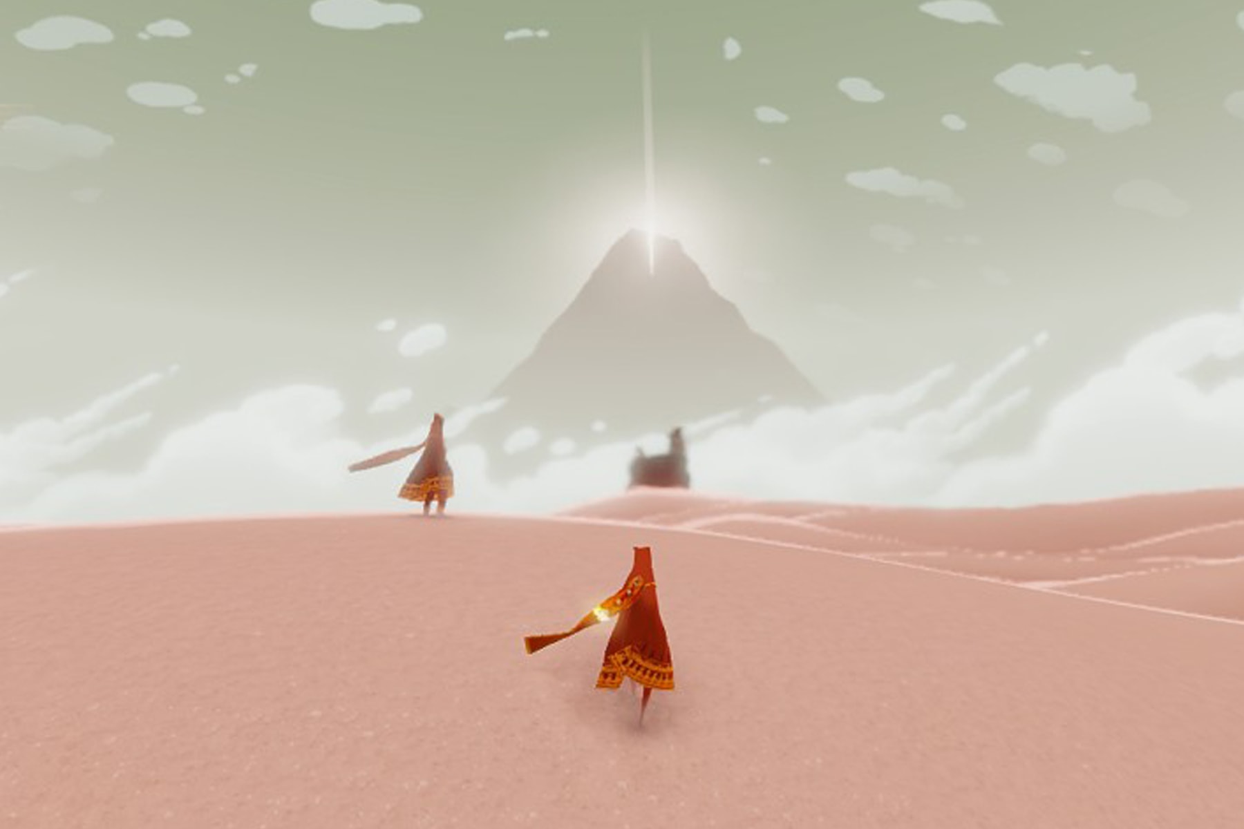 Screenshot from Playstation 3 game Journey, featuring characters walking on pink sand toward a mountain