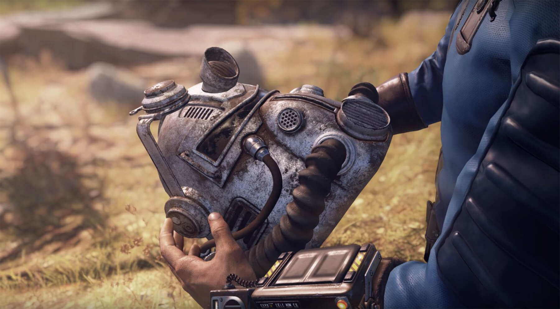 A Fallout 76 character holds a nuclear radiation helmet. 