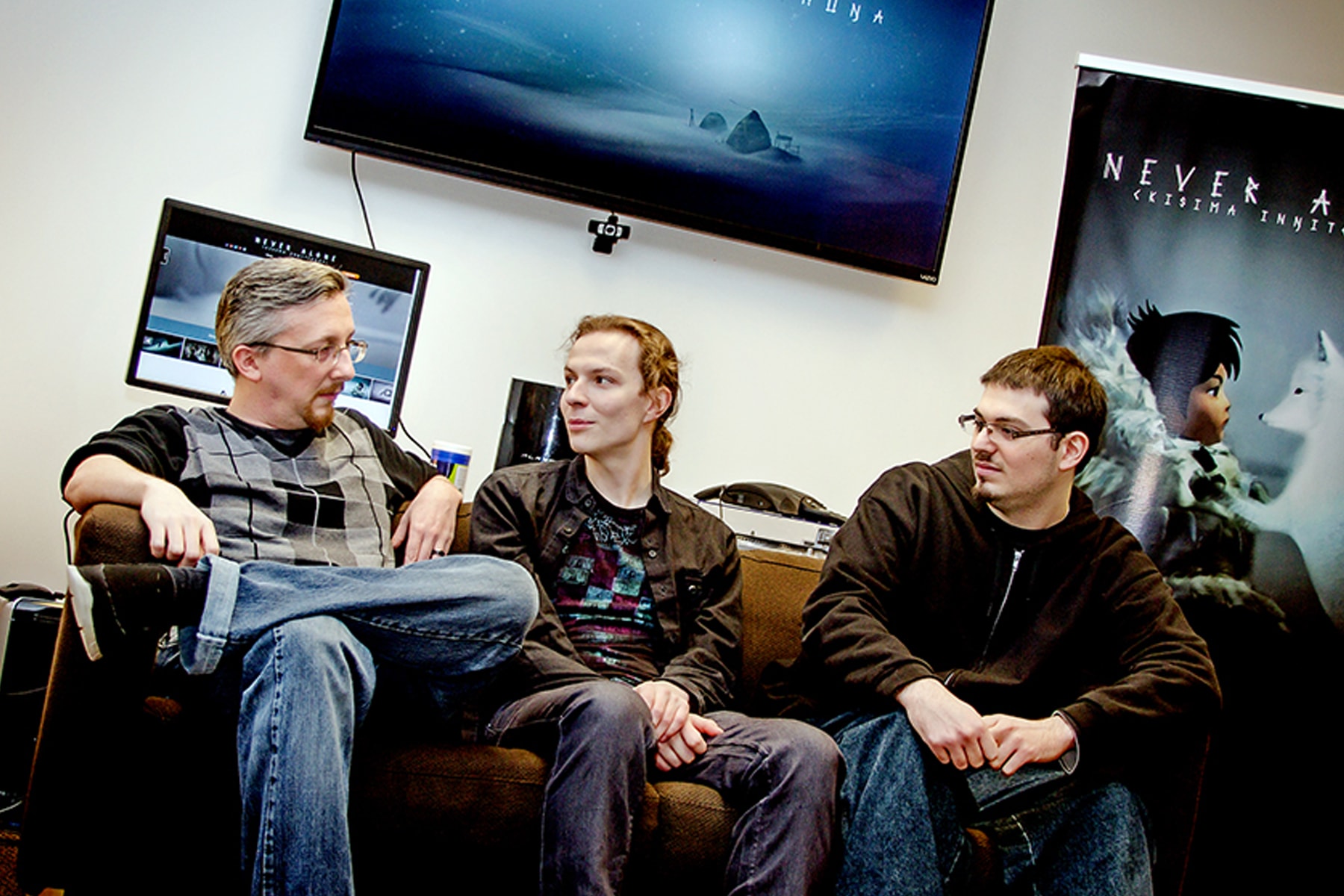 DigiPen alumni Matt Swanson, Alexei Gill, and Vincent Leone sitting on a couch in the E-Line Media office