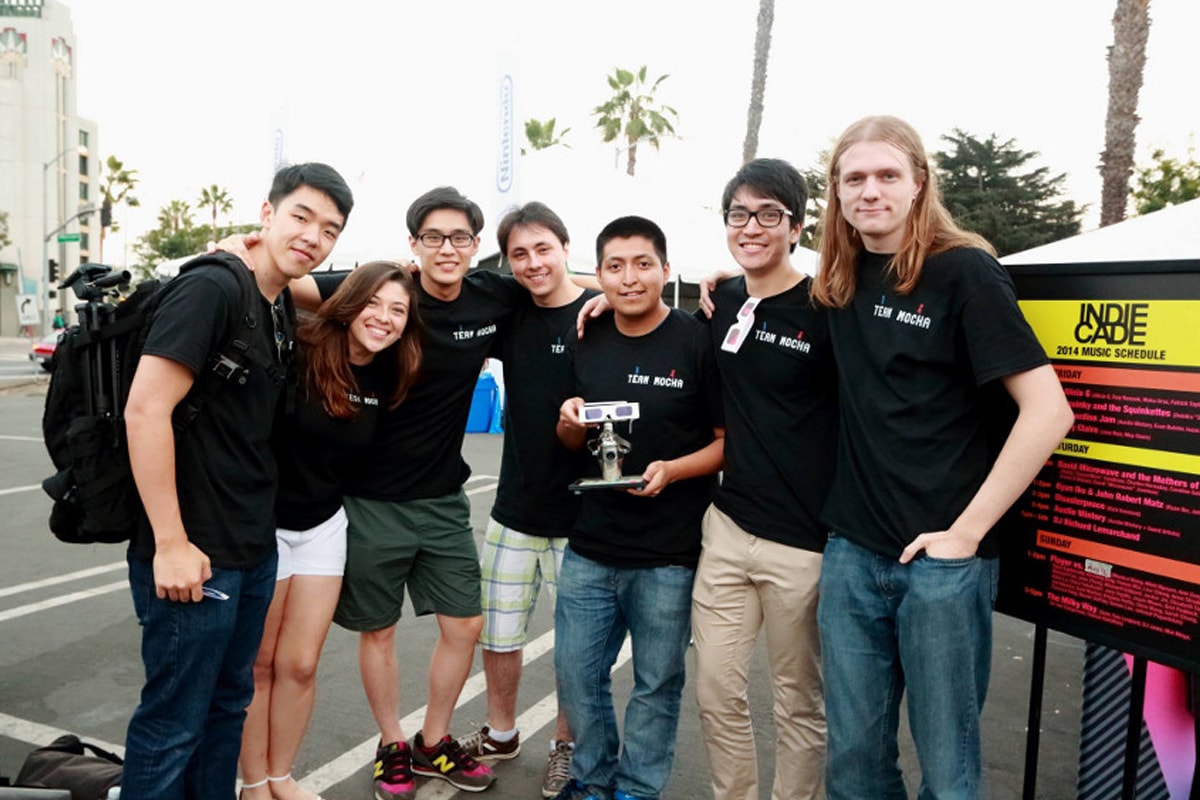 Seven members of DigiPen student game Team Mocha hold their award outside IndieCade