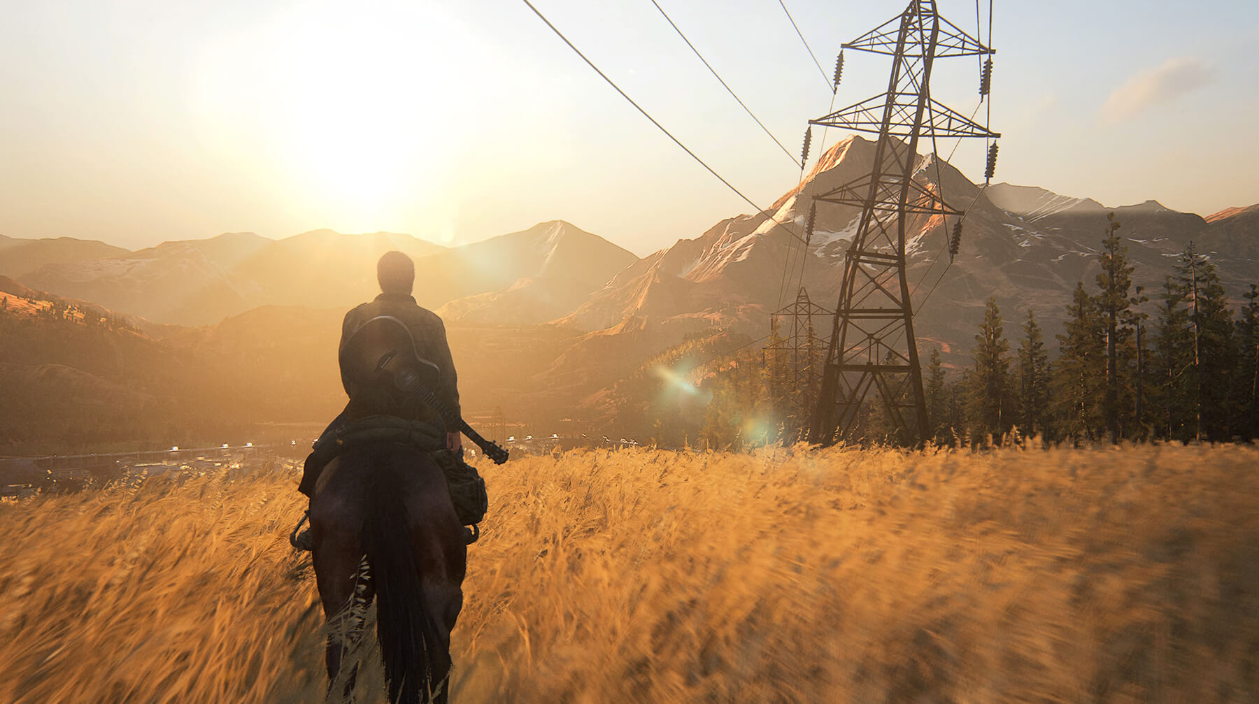 Ellie rides on horseback over a golden field with mountains in the background