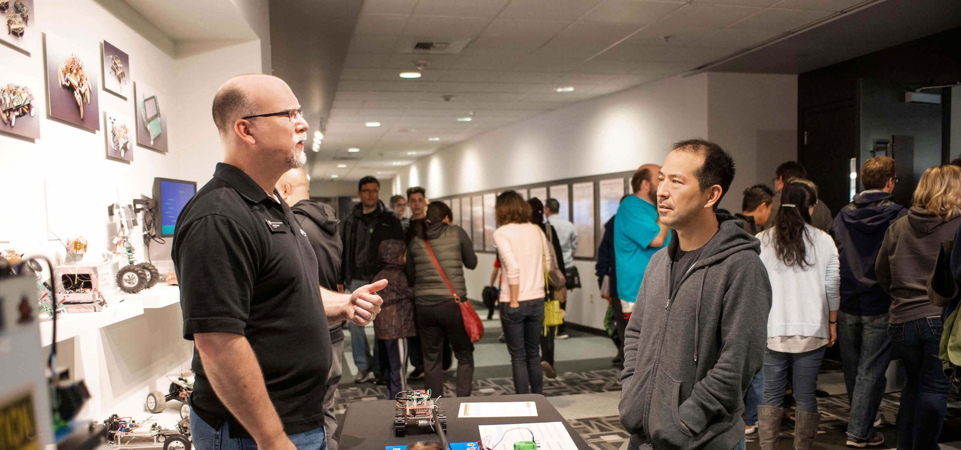 A DigiPen staff member speaks with a prospective student at a Preview Day event