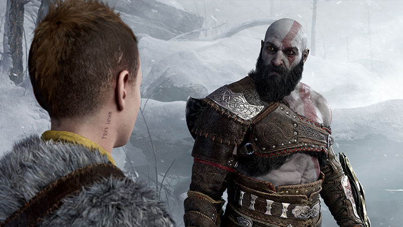 Kratos character from God of War Ragnarok looks sternly at his son, Atreus, in a snowy environment.