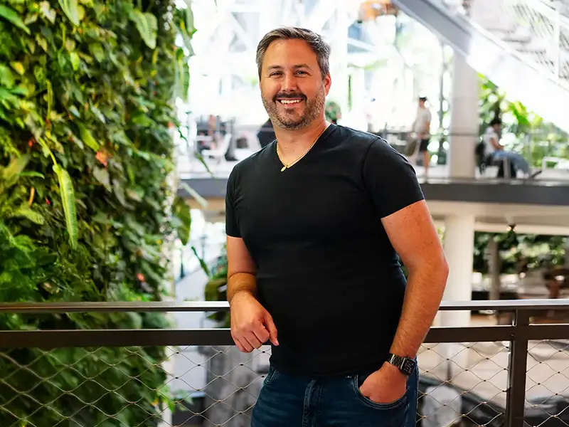 Jonathan Wills poses next to a wall full of plants in The Spheres at Amazon HQ in Seattle.