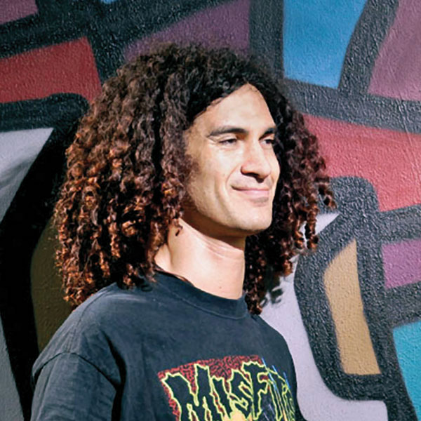 DigiPen alumnus Mike Kersey smiling in front of a brightly colored wall