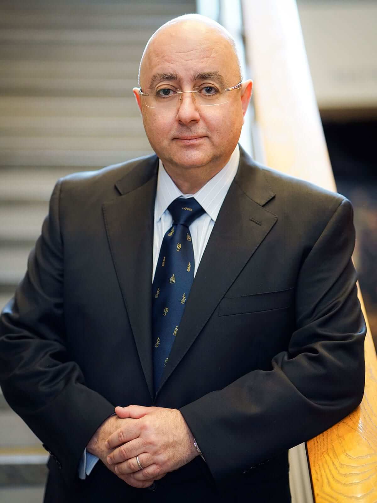 DigiPen president and founder Claude Comair poses on a staircase in 2018