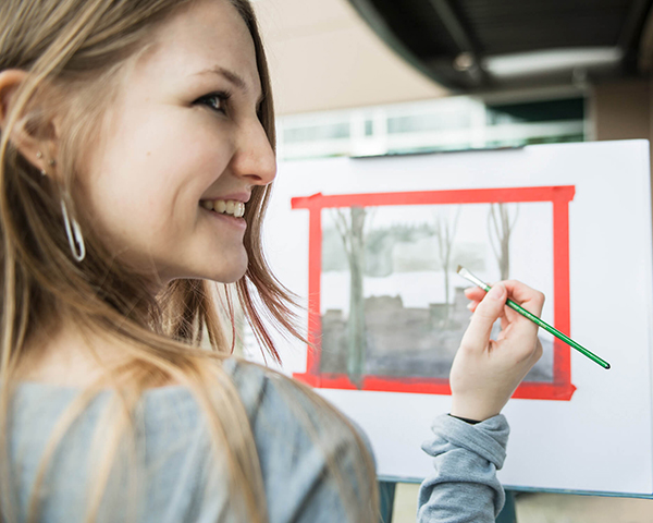 A DigiPen art student paints a watercolor landscape.