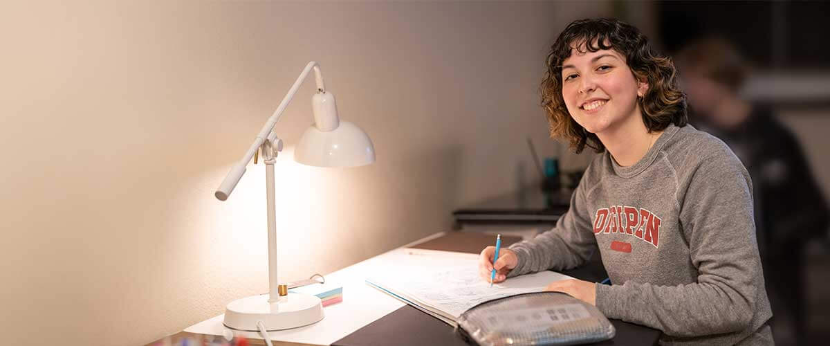 With pencil in hand, a student smiles as she makes progress on her studies.