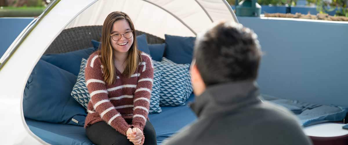 A student eagerly chats with a member of the financial aid team.