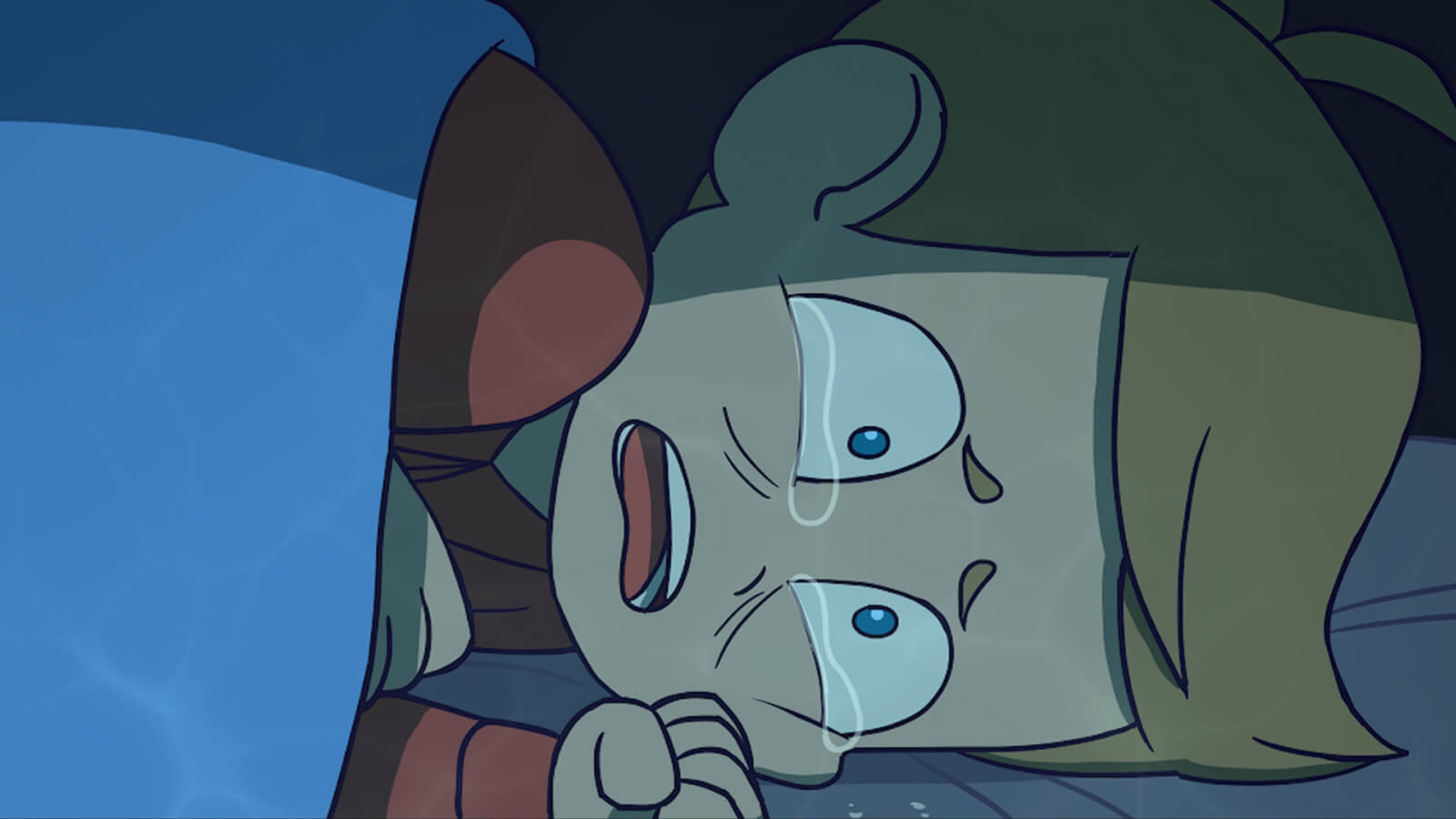 A boy crying on his side in bed.