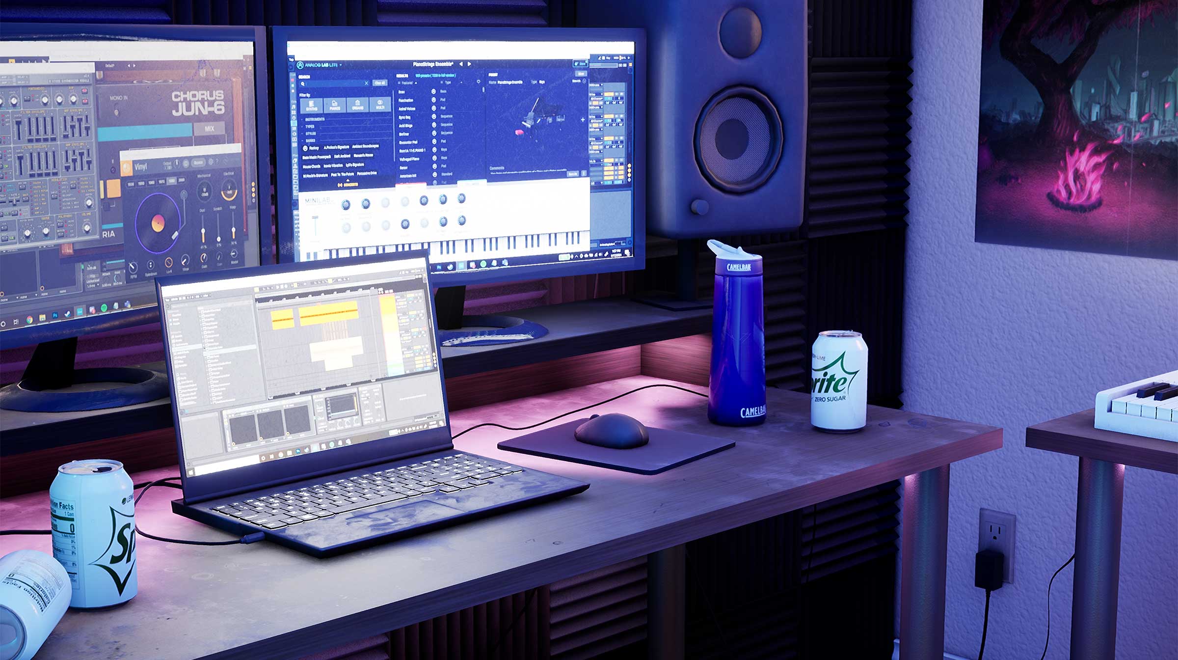 A laptop and computer setup on a desk in a low-lit room.