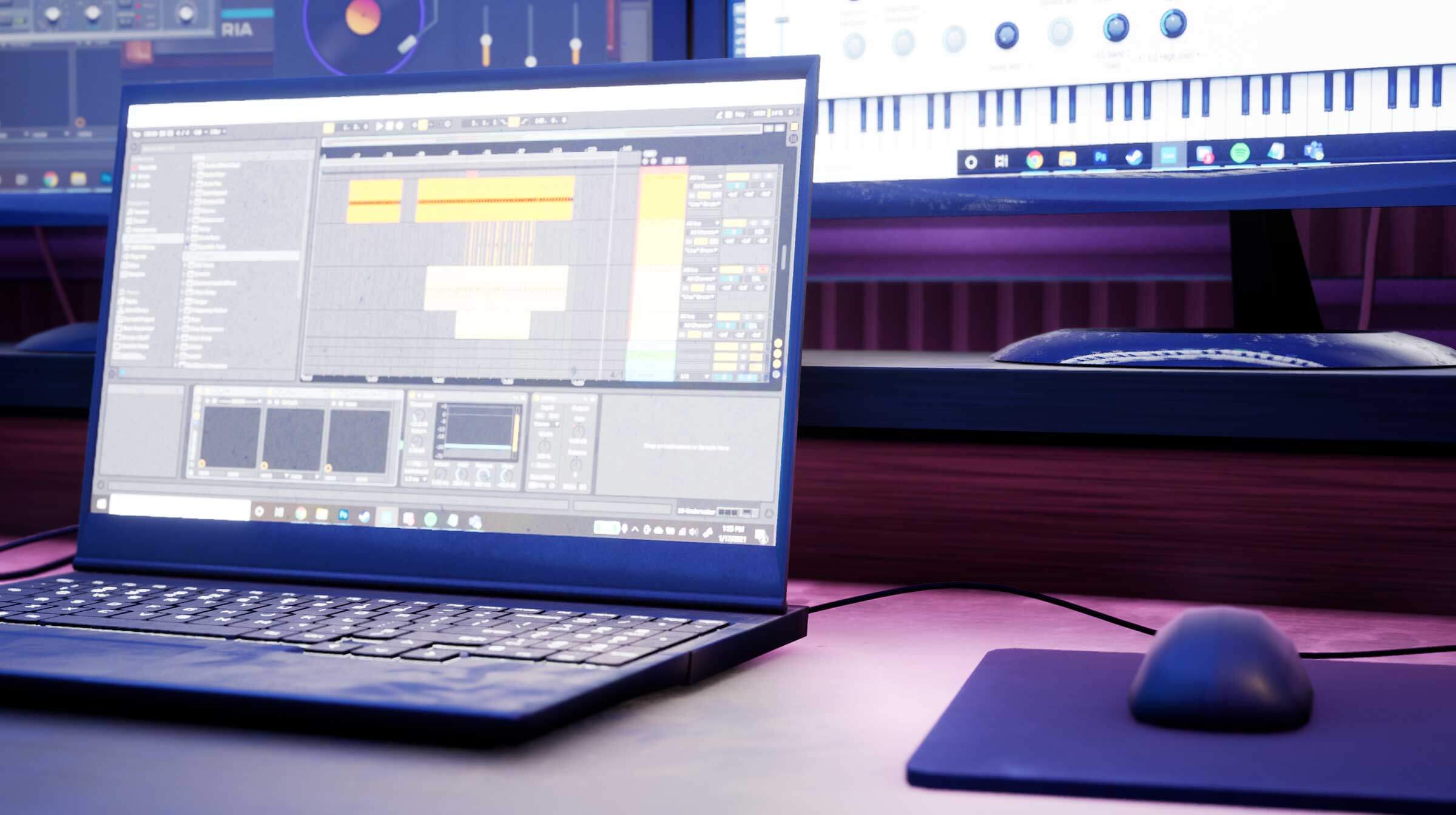 A laptop and mouse rest on a desk in a low-lit room.