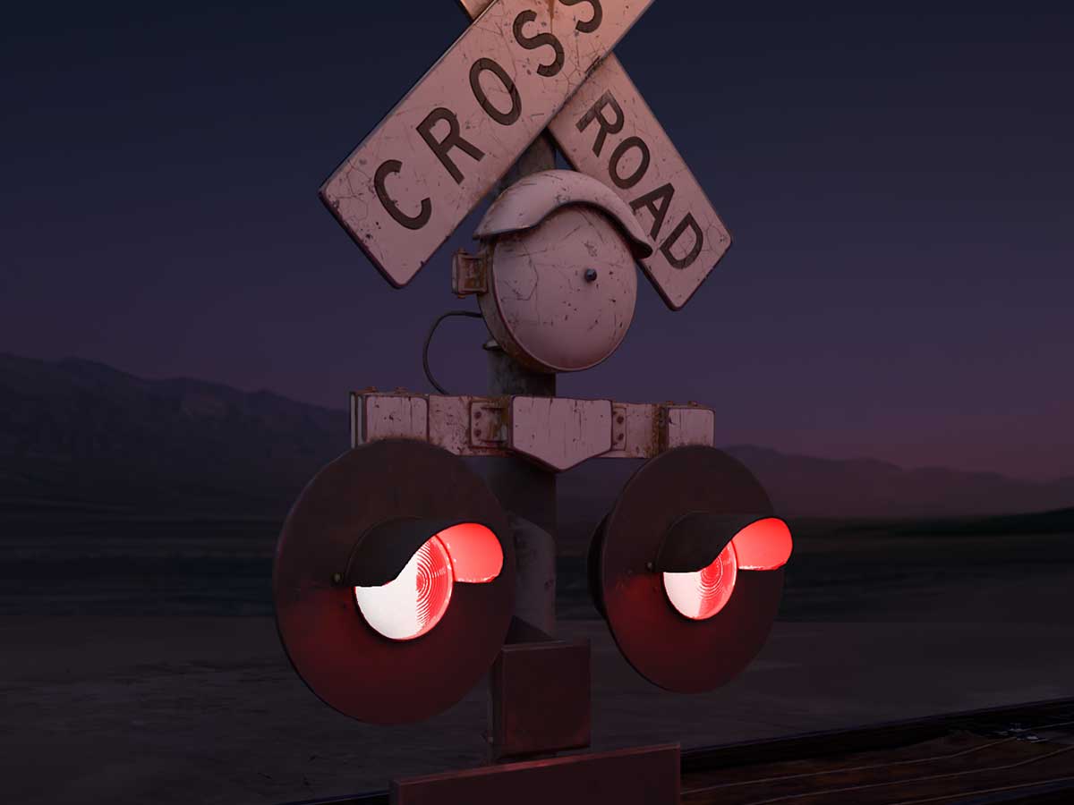 An illuminated railroad crossing sign in a flat, desert nightscape.