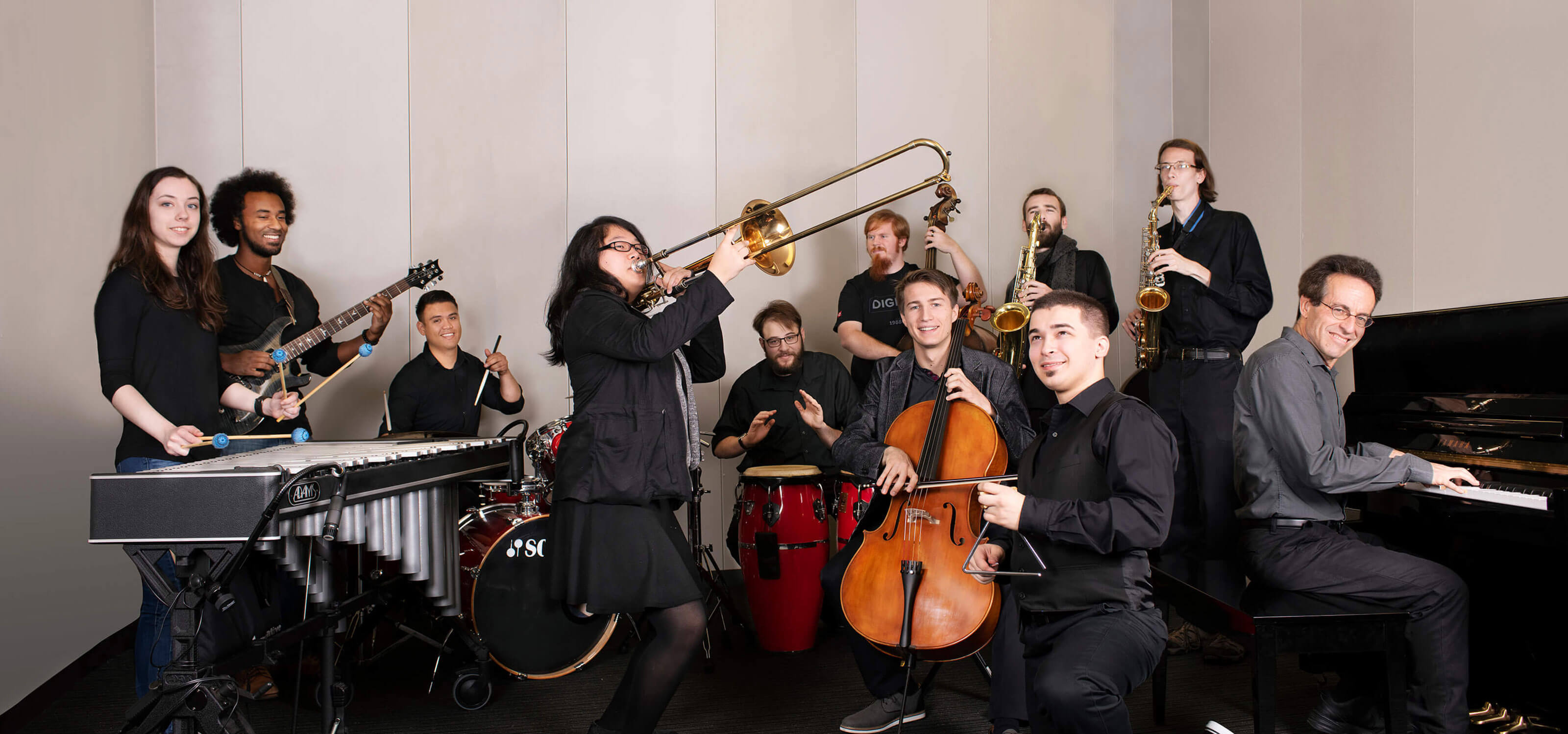 The DigiPen Jazz Ensemble posing with their instruments in a sound lab on campus