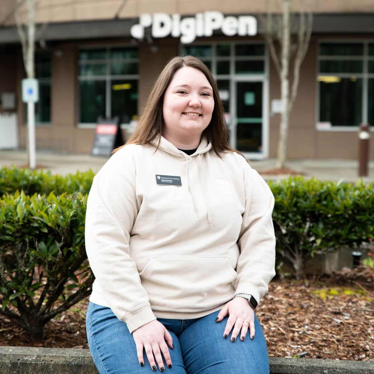 DigiPen Student Success Advisor sitting outside in front of DigiPen's Redmond Campus