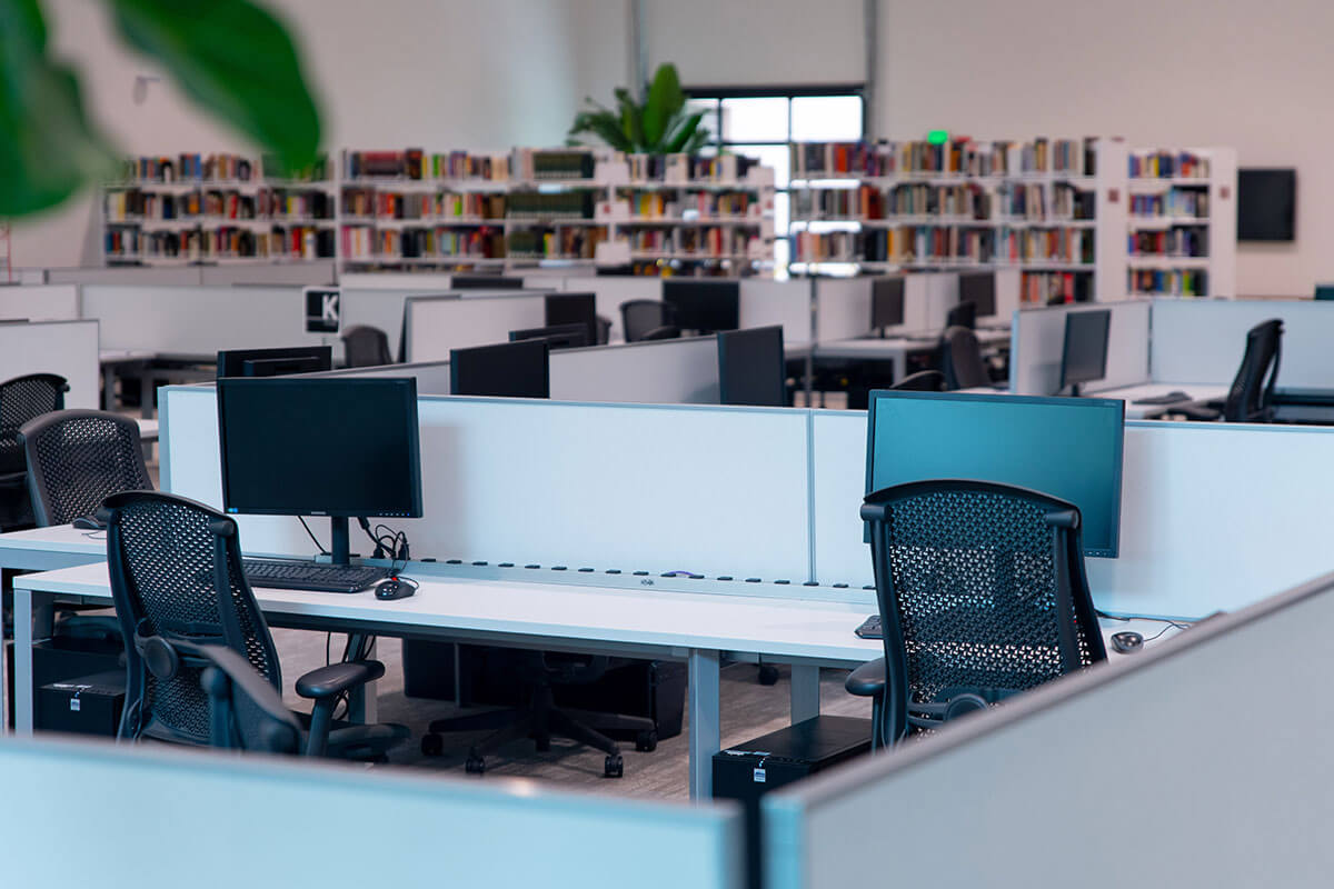 A computer lab with bookshelves in the background.