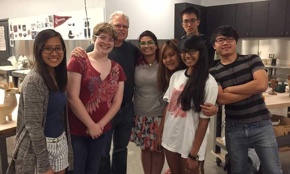 OIP and Redmond students pose with a teacher in a classroom