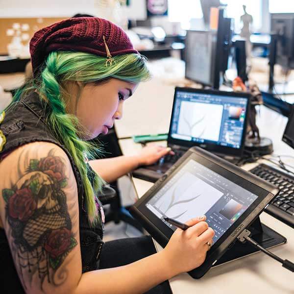 A DigiPen student digitally drawing on a tablet