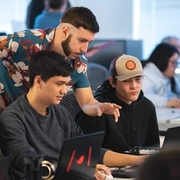 A group of DigiPen student collaborating around a computer