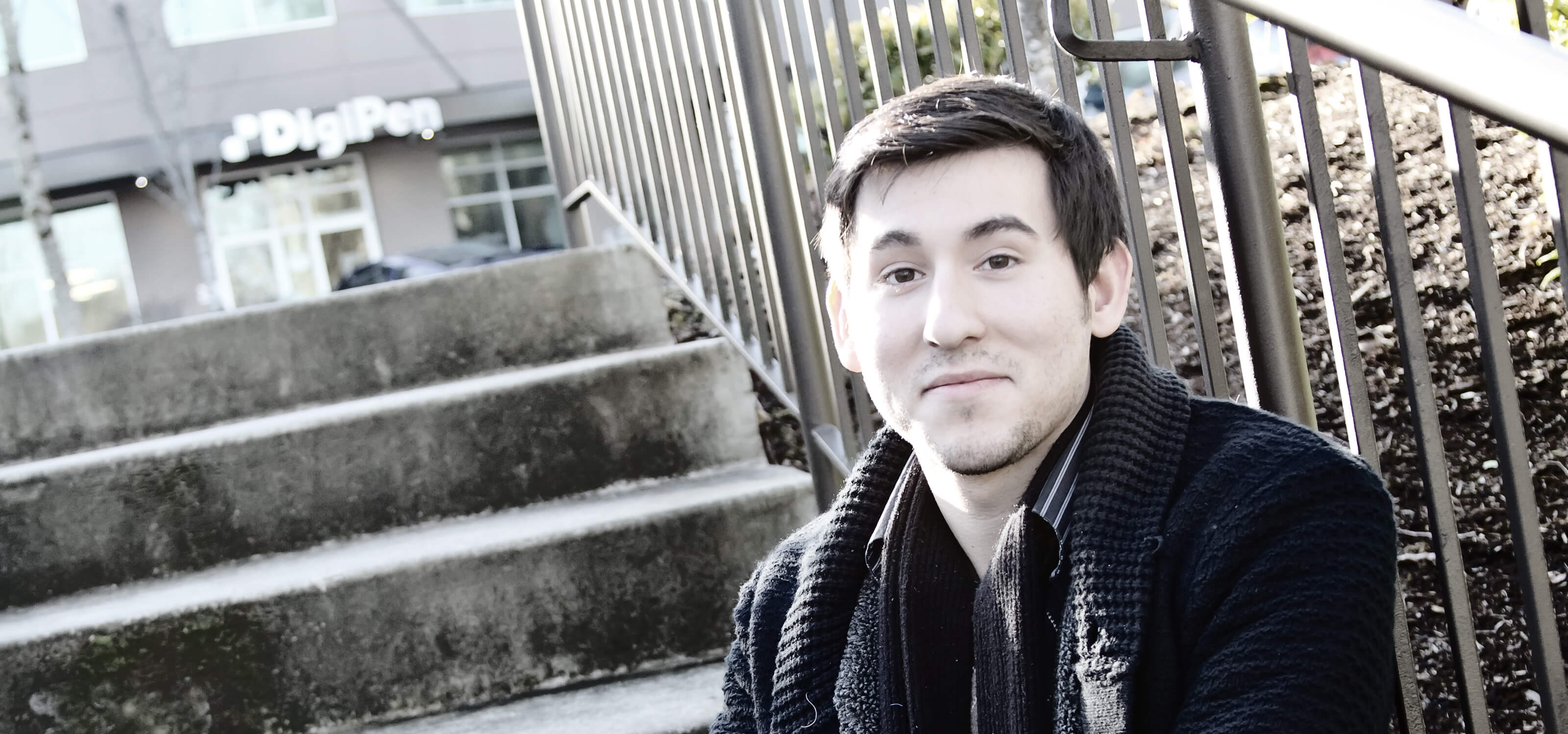 DigiPen student Andrew Alvarez posing on stairs outside the DigiPen building