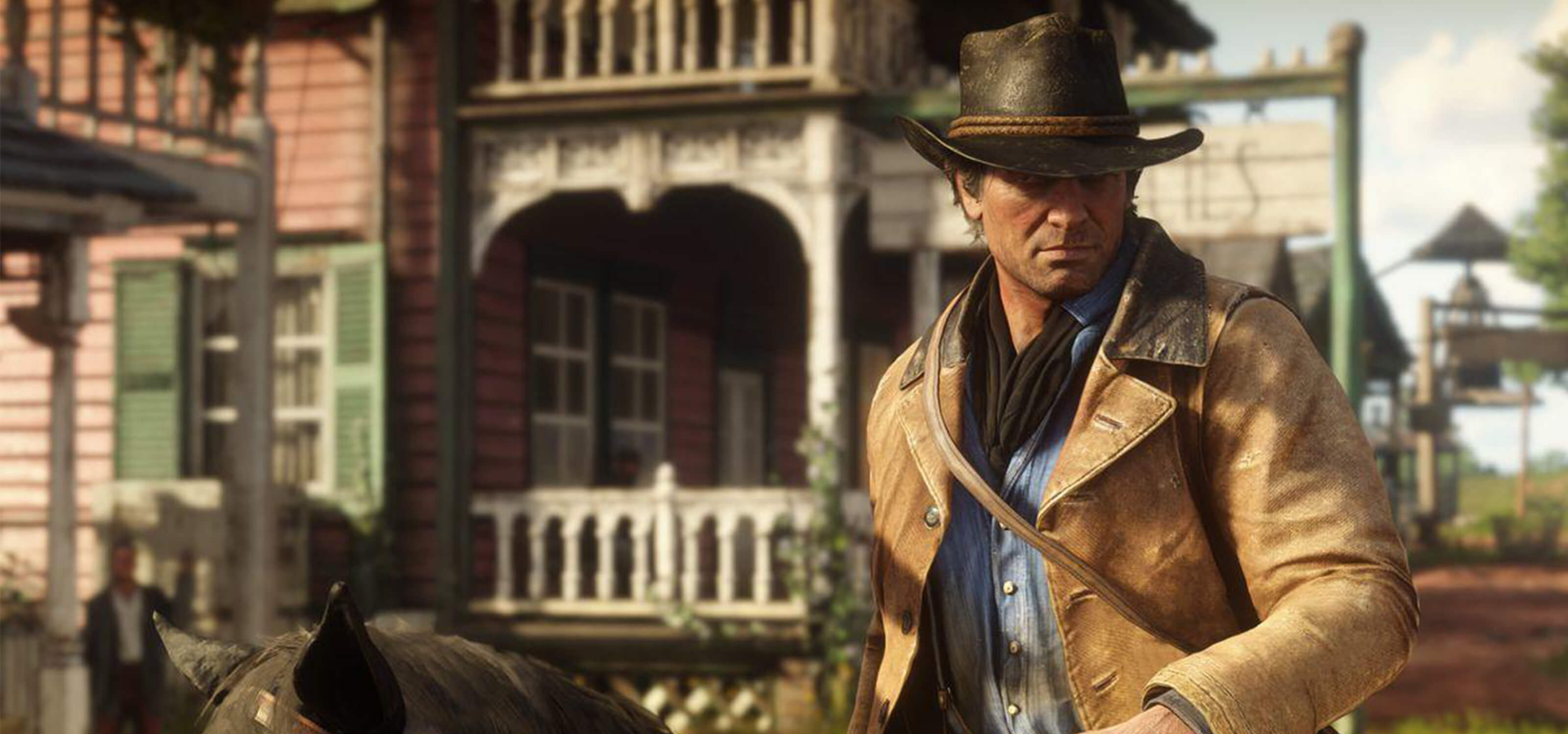 Red Dead Redemption 2’s protagonist Arthur Morgan rides into town on his horse.