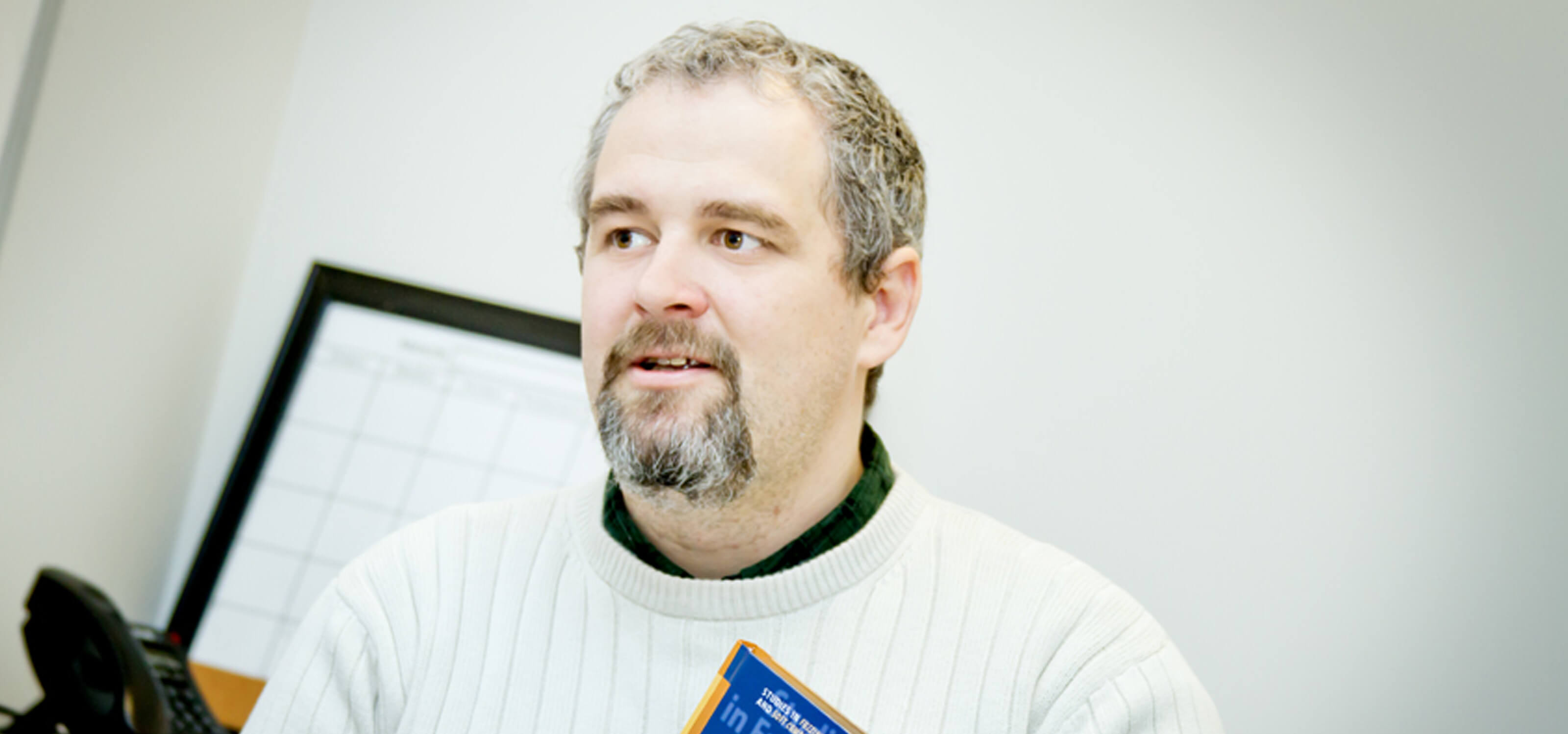 DigiPen mathematics professor Dr. Barnabas Bede holding a copy of his book, Mathematics of Fuzzy Sets and Fuzzy Logic