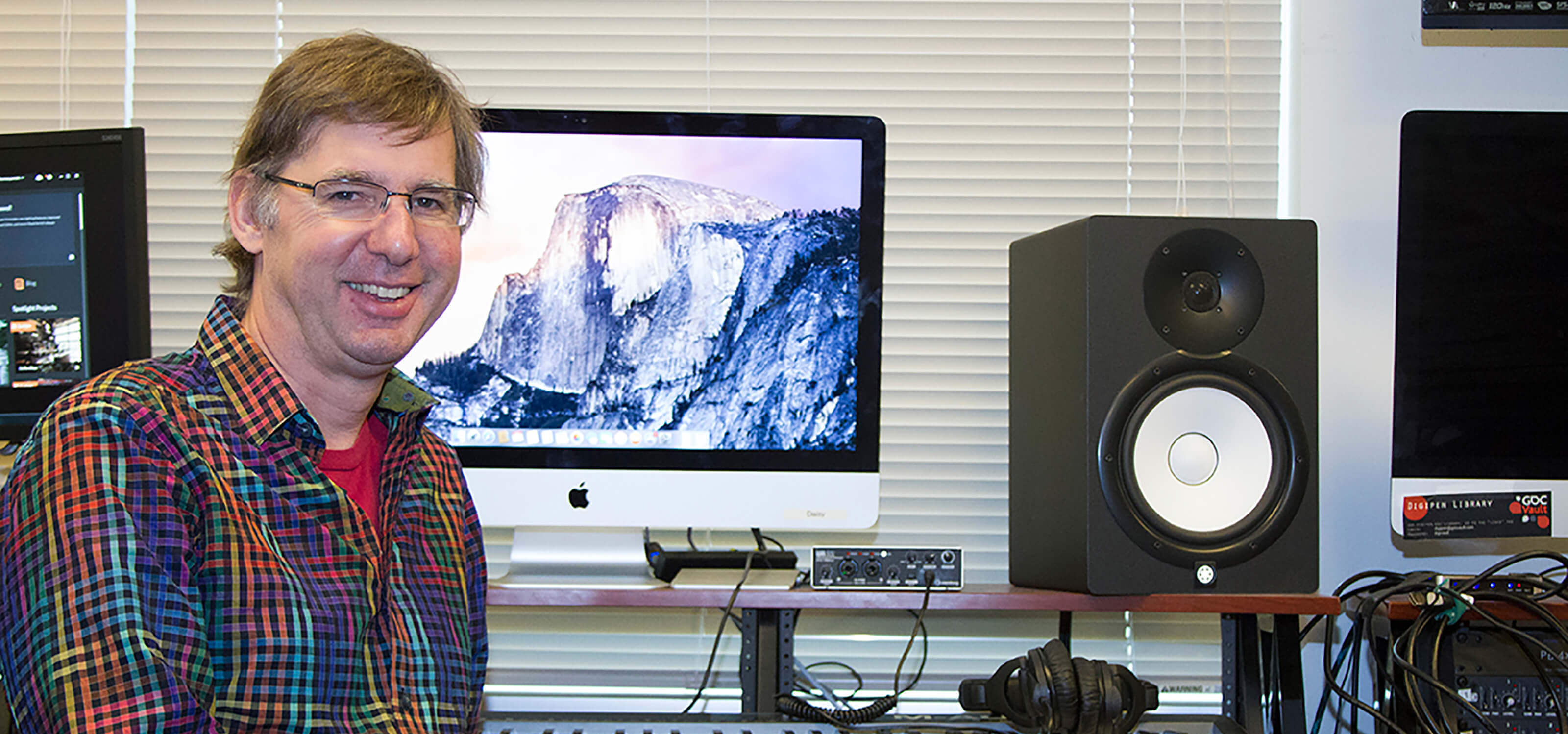 DigiPen music senior lecturer Brian Schmidt sits in front of a computer in the DigiPen sound lab