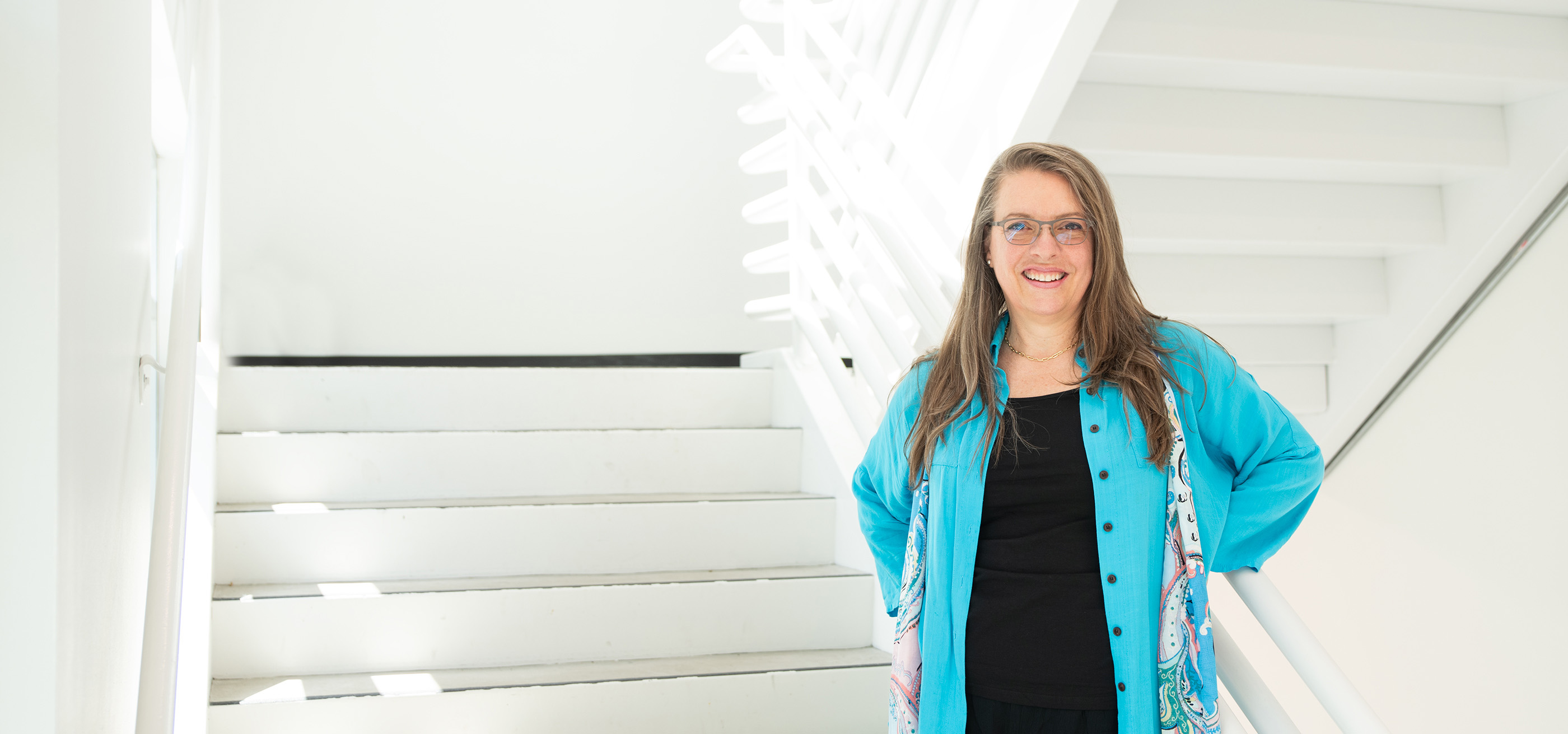 Brigitte Samson stands and smiles inside the DigiPen building.