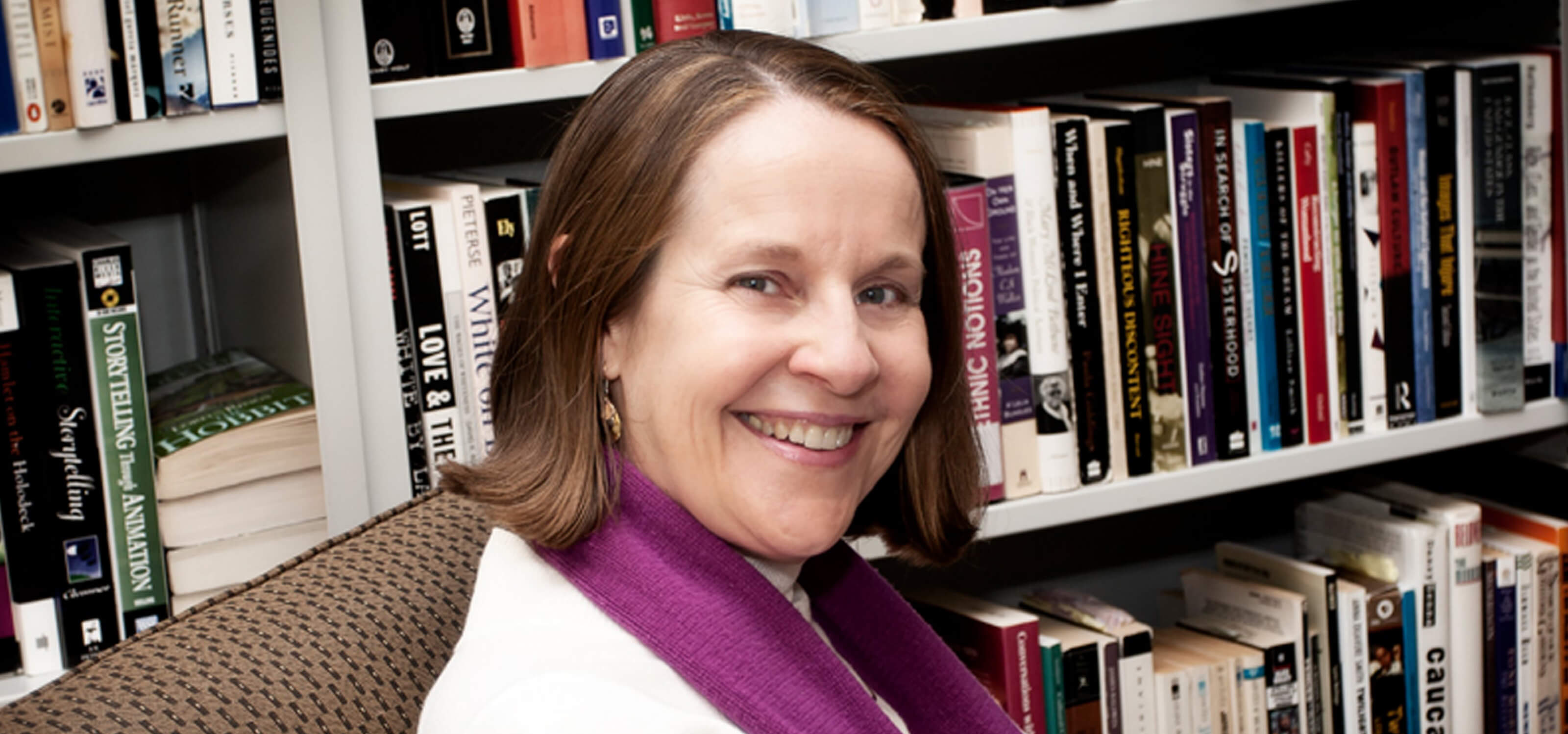 Portrait of DigiPen humanities professor Claire Joly in front of bookshelves in the campus library