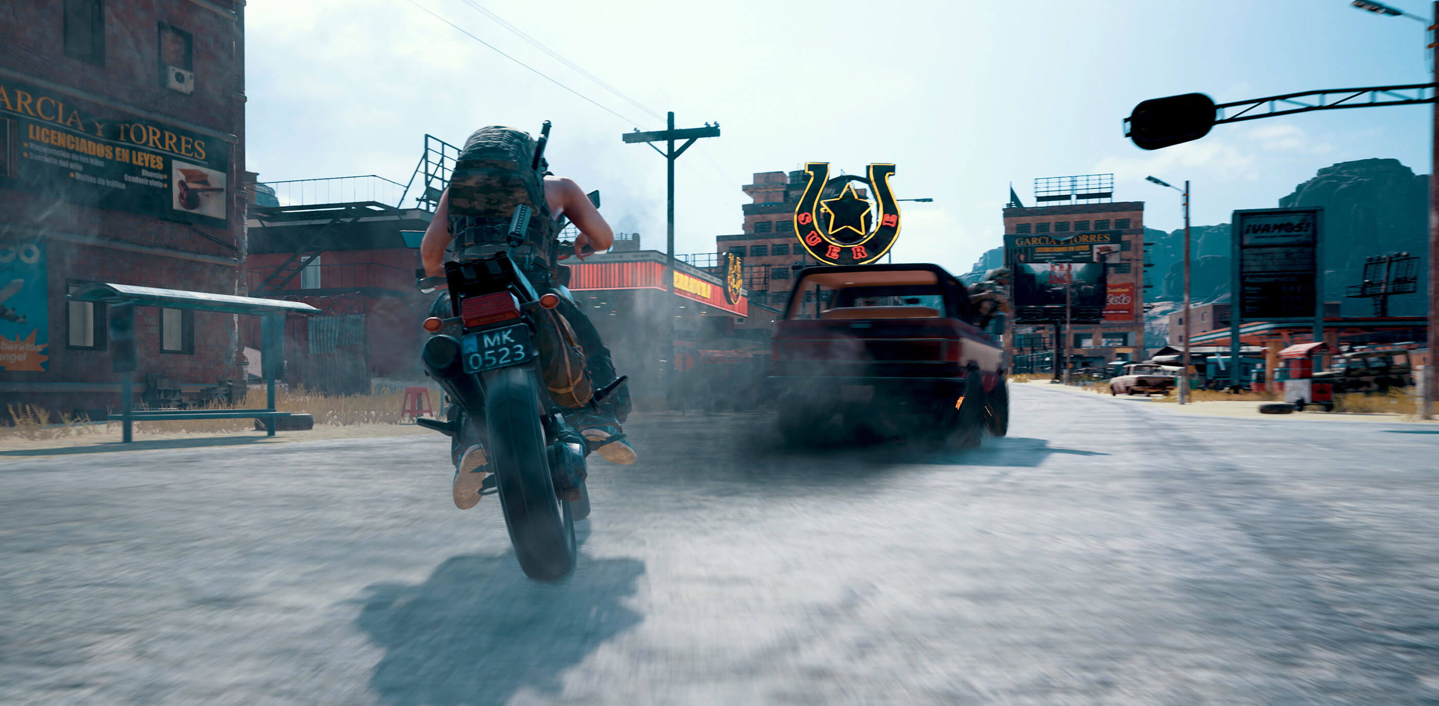A player on a motorcycle chases a smoking truck down a western themed street