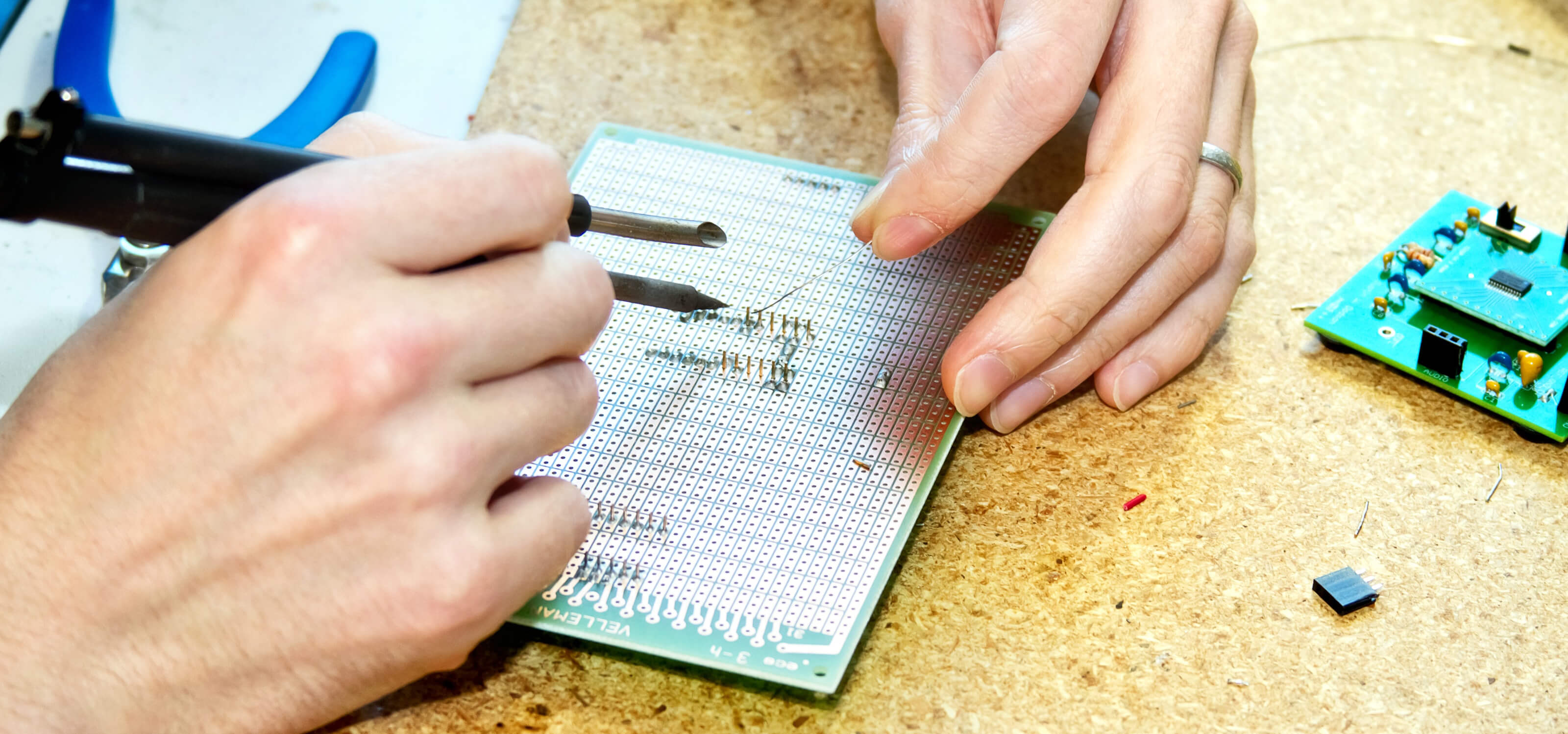 Close-up of a DigiPen student doing detailed work on a small circuit board