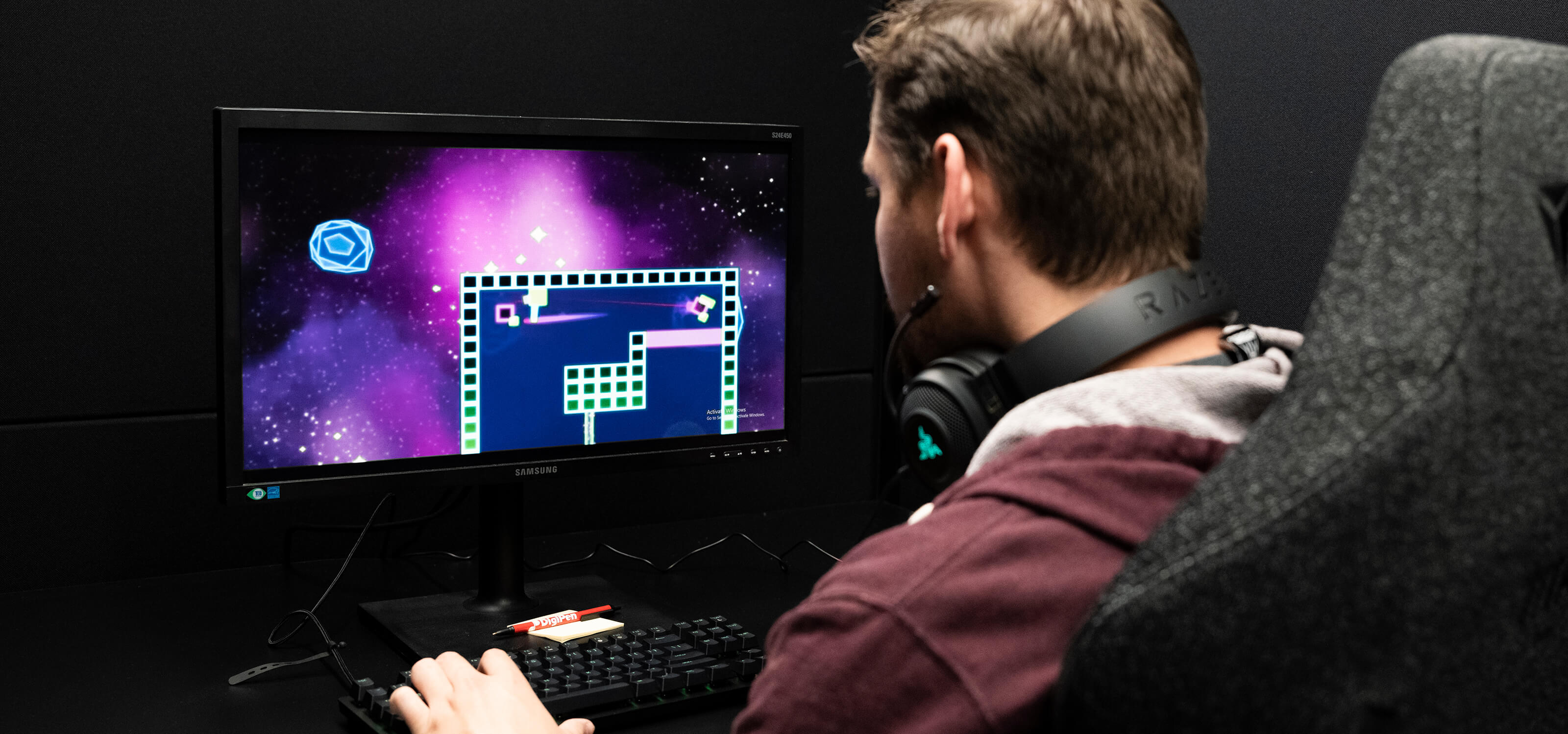 A DigiPen student plays a PC game in a Nightingale lab testing bay.