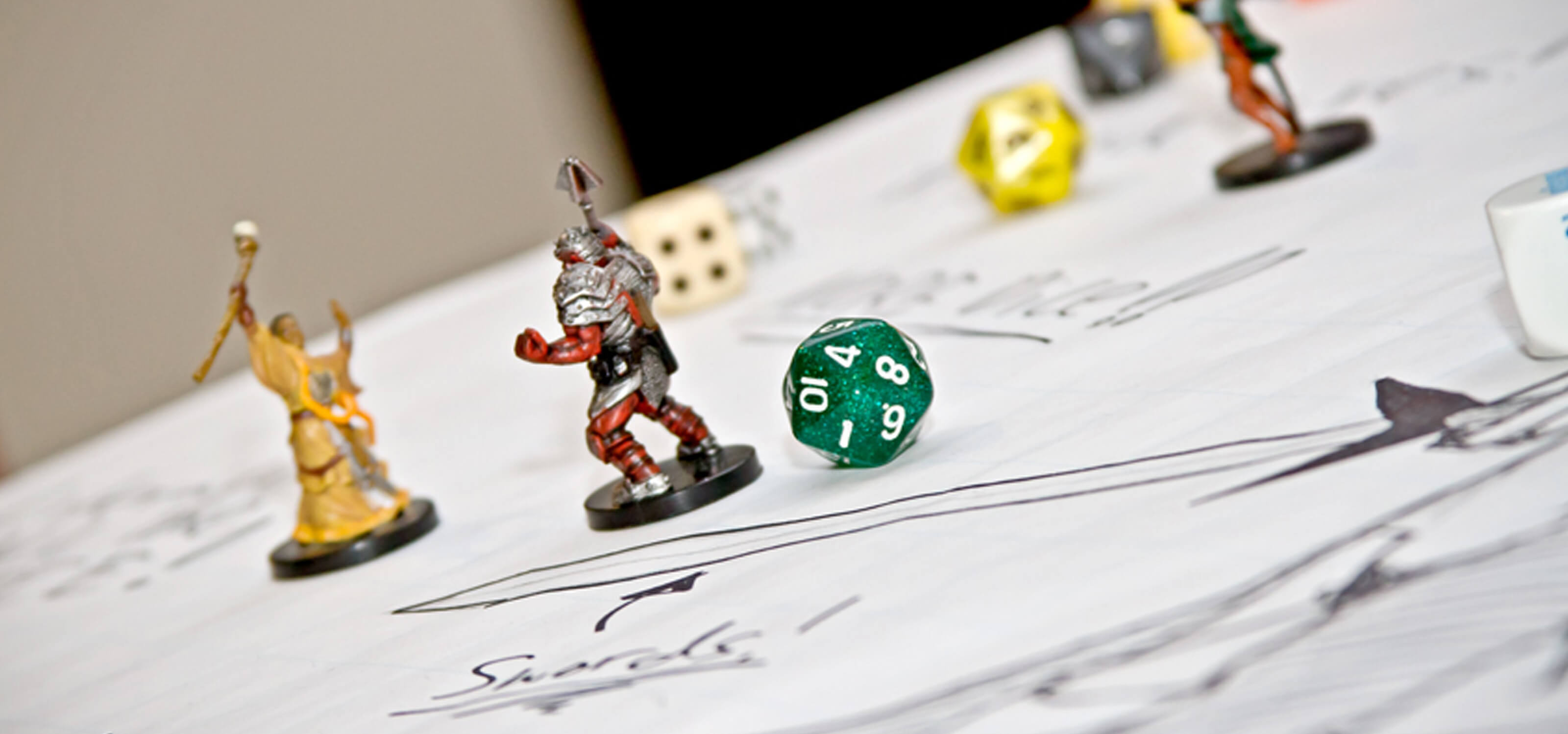 Close-up of board game figurines and 10-sided die