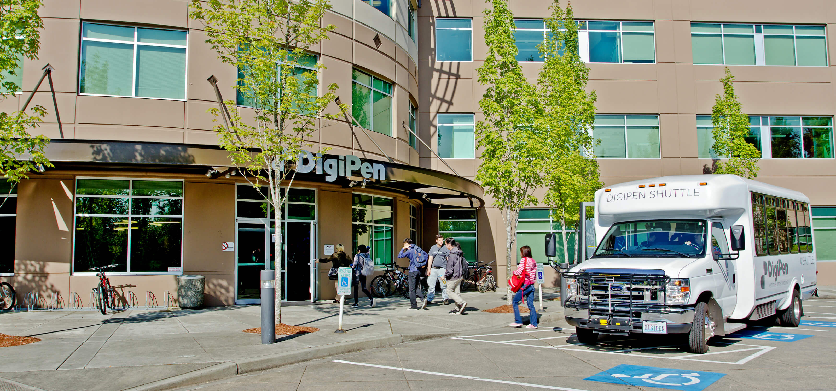 Students getting off the DigiPen shuttle bus in front of the DigiPen building