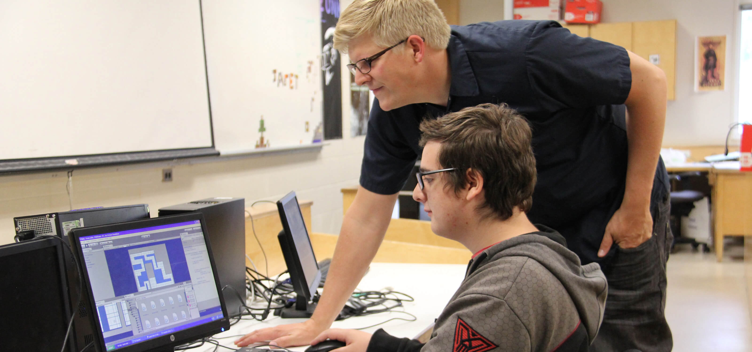 Student and teacher looking at a computer monitor in a Kamloops, British Columbia classroom