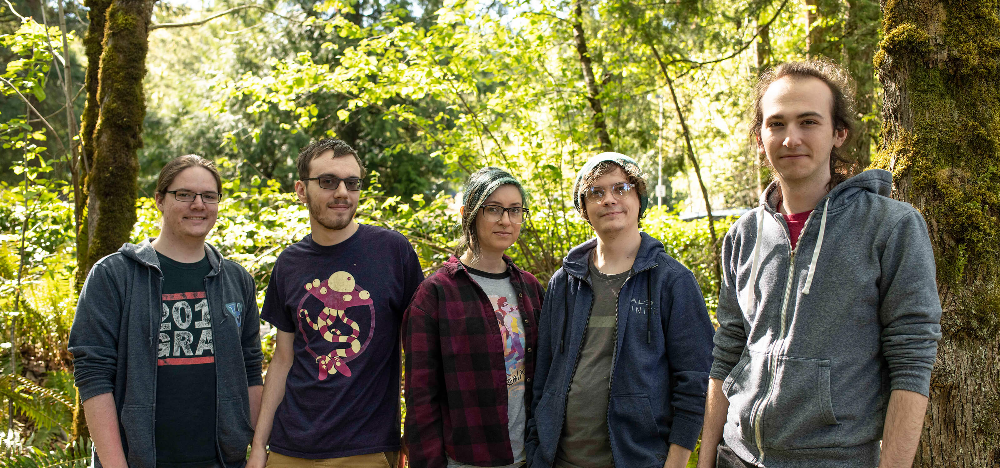 Student game team Free Minds poses in front of the Redmond forests that inspired The Pilgrim.