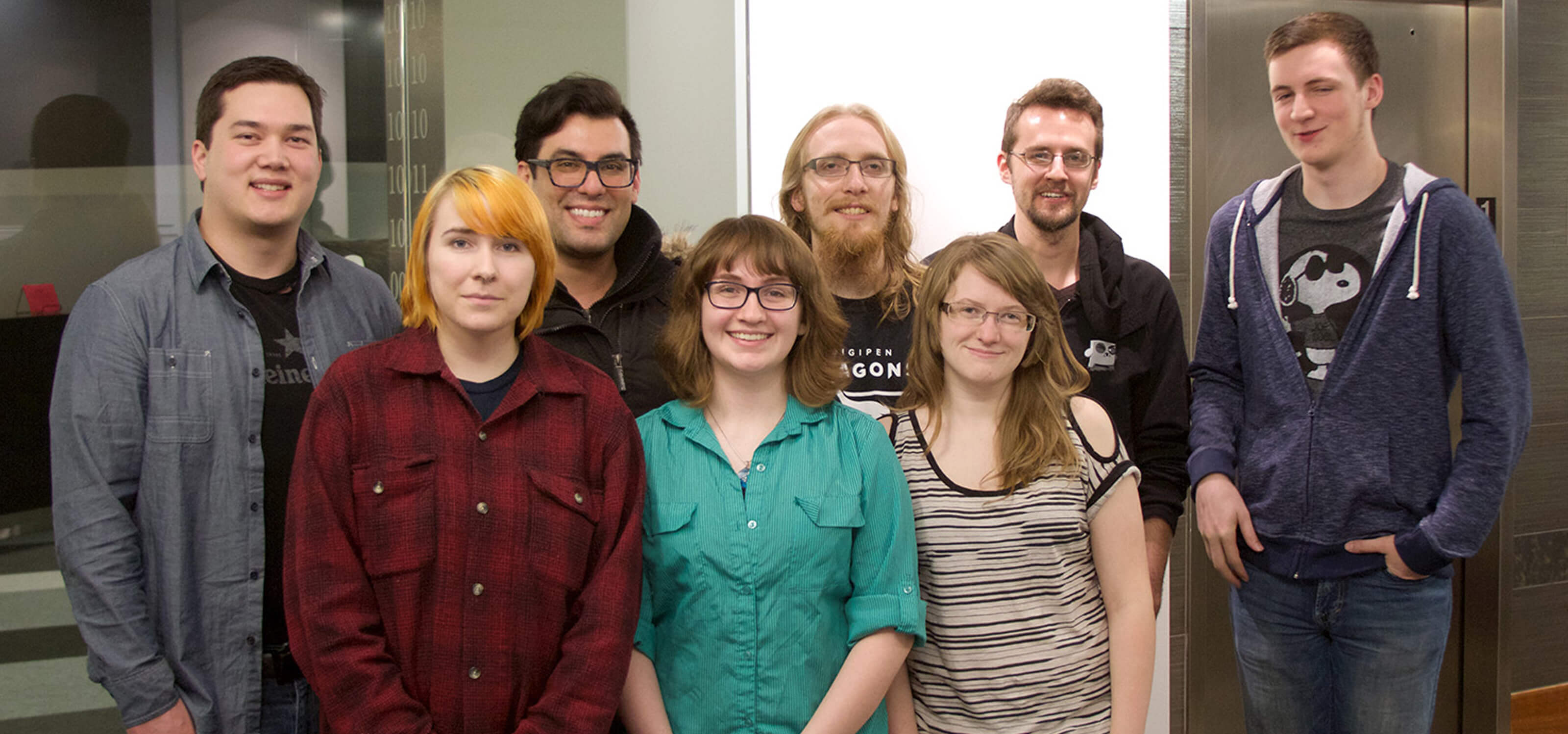 Eight members of Team Overboard smiling in the DigiPen lobby