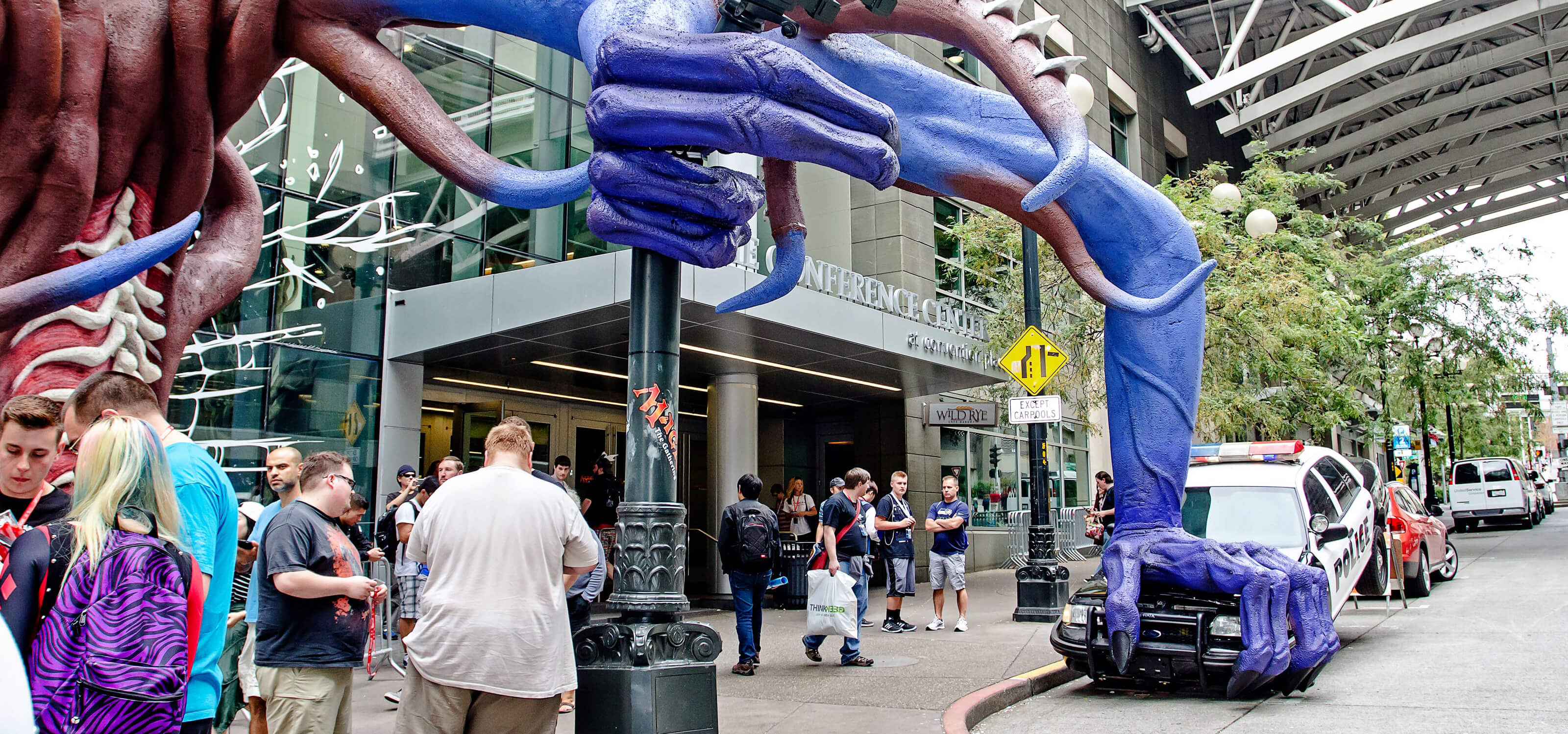 A huge clawed hand crushes a police car outside the Washington State Convention Center for PAX 2015