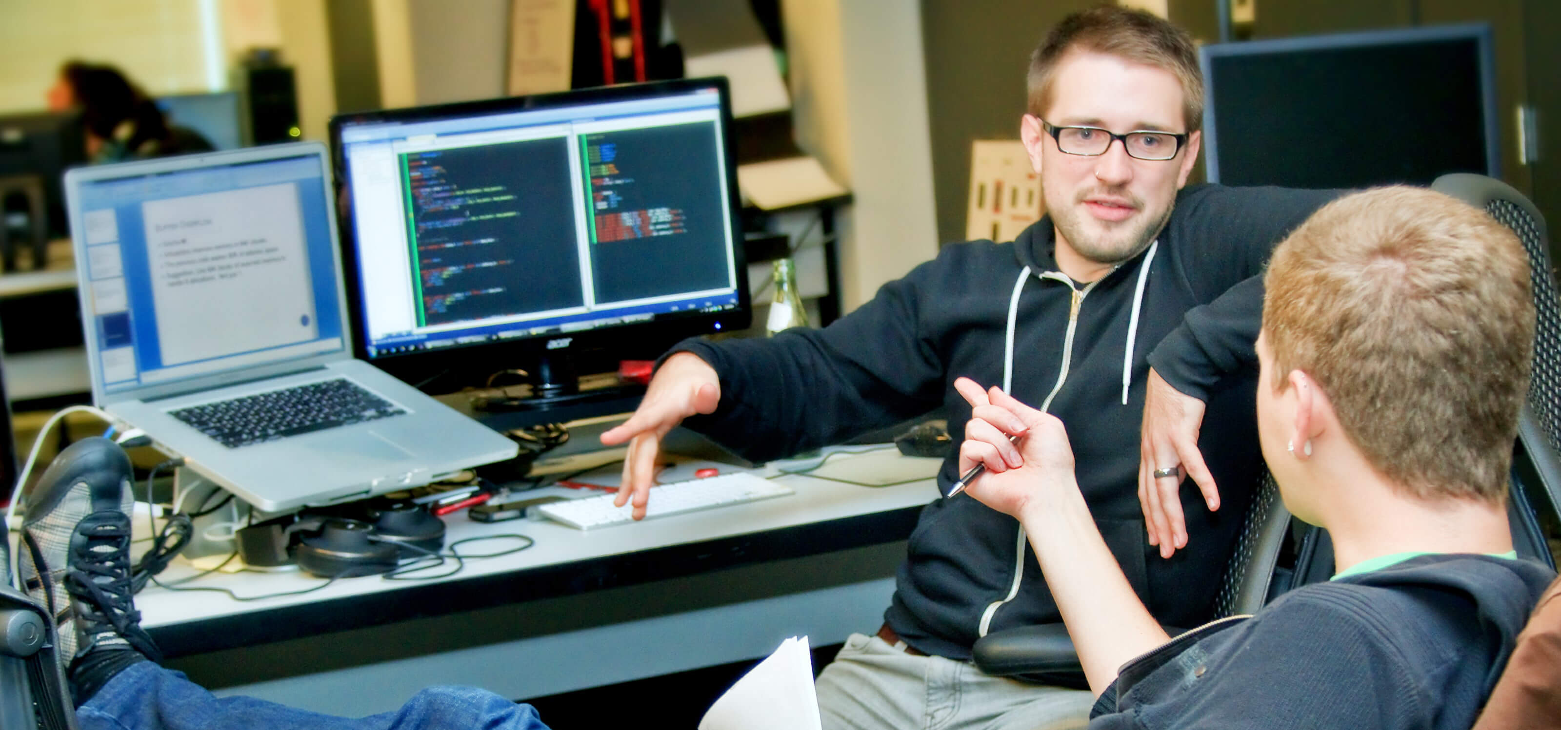 Two students chatting in their team space on the DigiPen campus