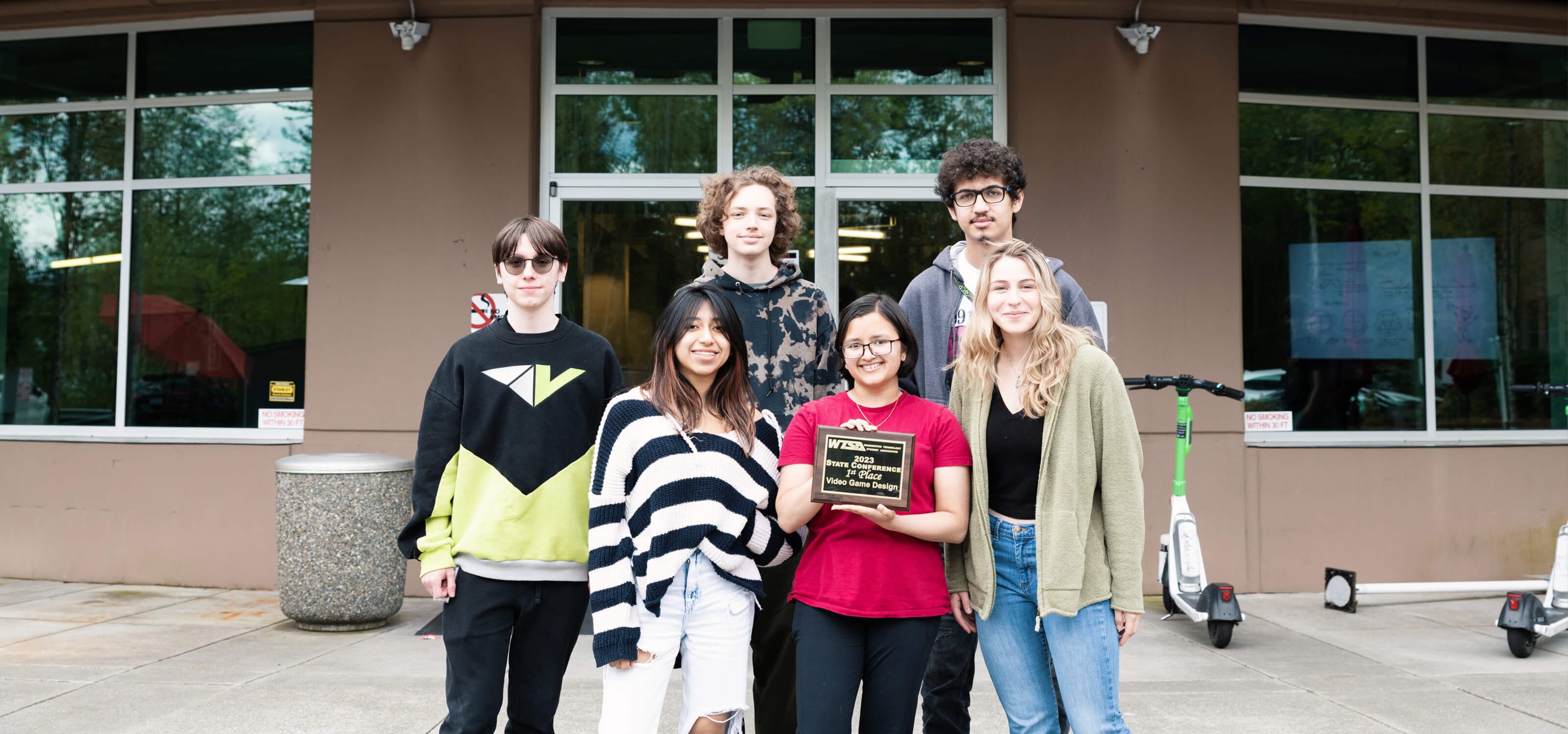 Group photo of six DigiPen WANIC students posing with first-place award plaque.