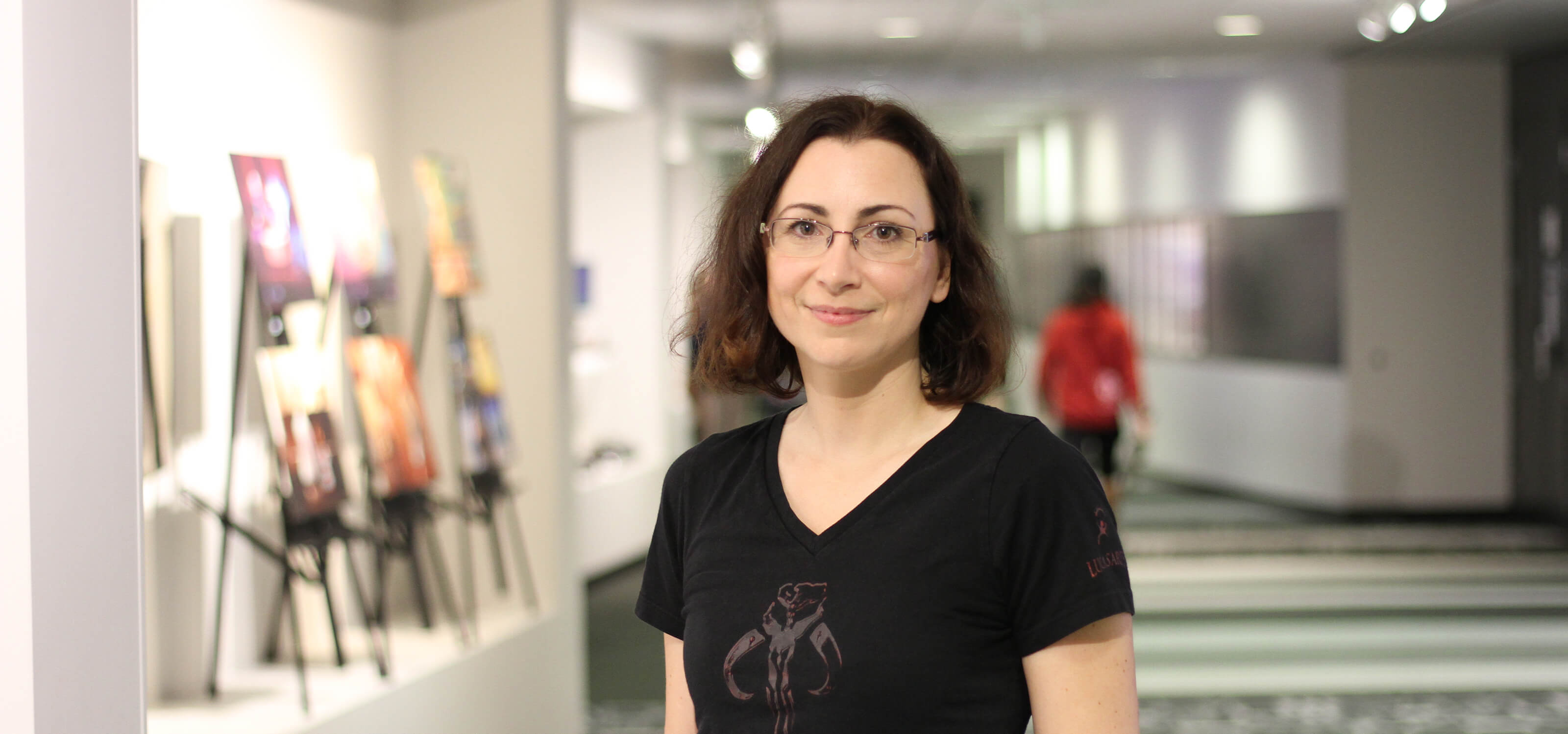 A profile shot of Dr. Celia Hodent standing in a DigiPen hallway.