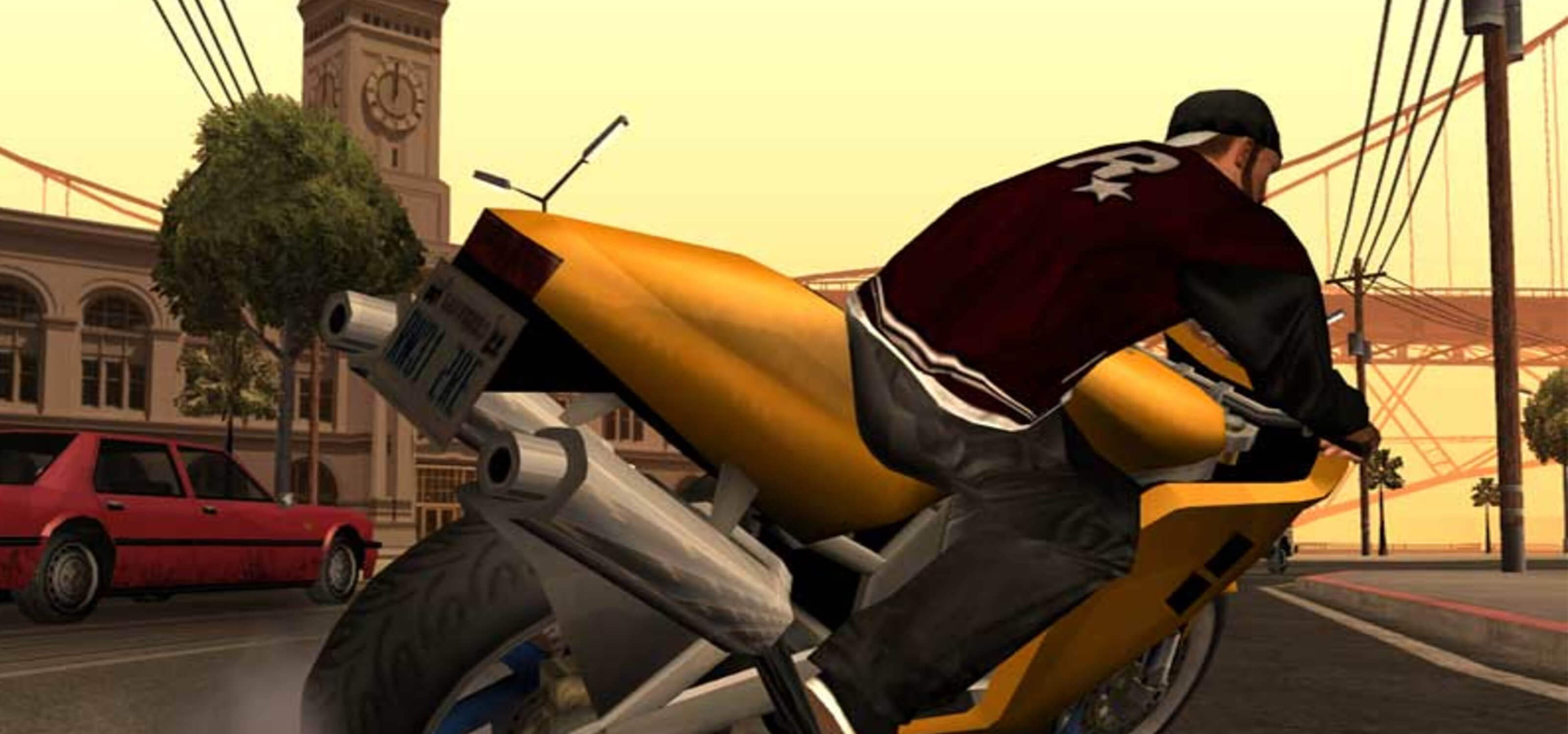A screenshot from Grand Theft Auto: San Andreas of a man in a jacket with the Rockstar logo on it riding a gold motorcycle.