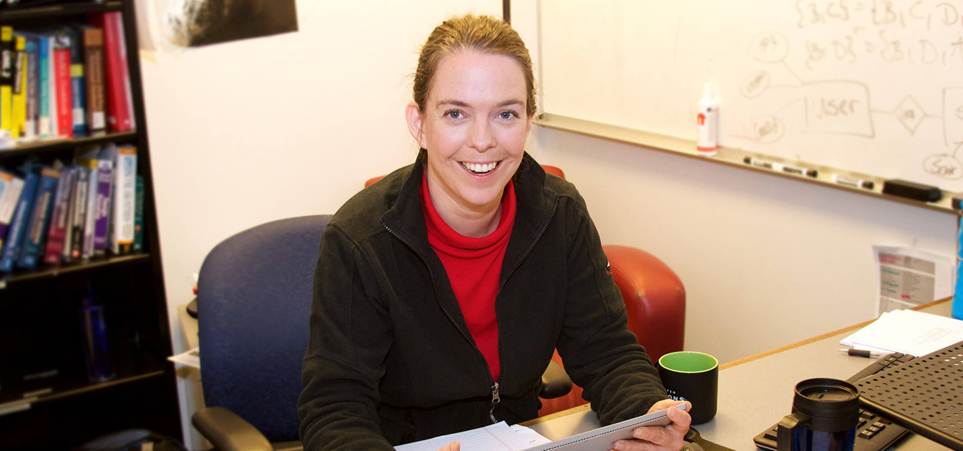 Professor Eva Iwer smiling while sitting at her desk in her DigiPen office
