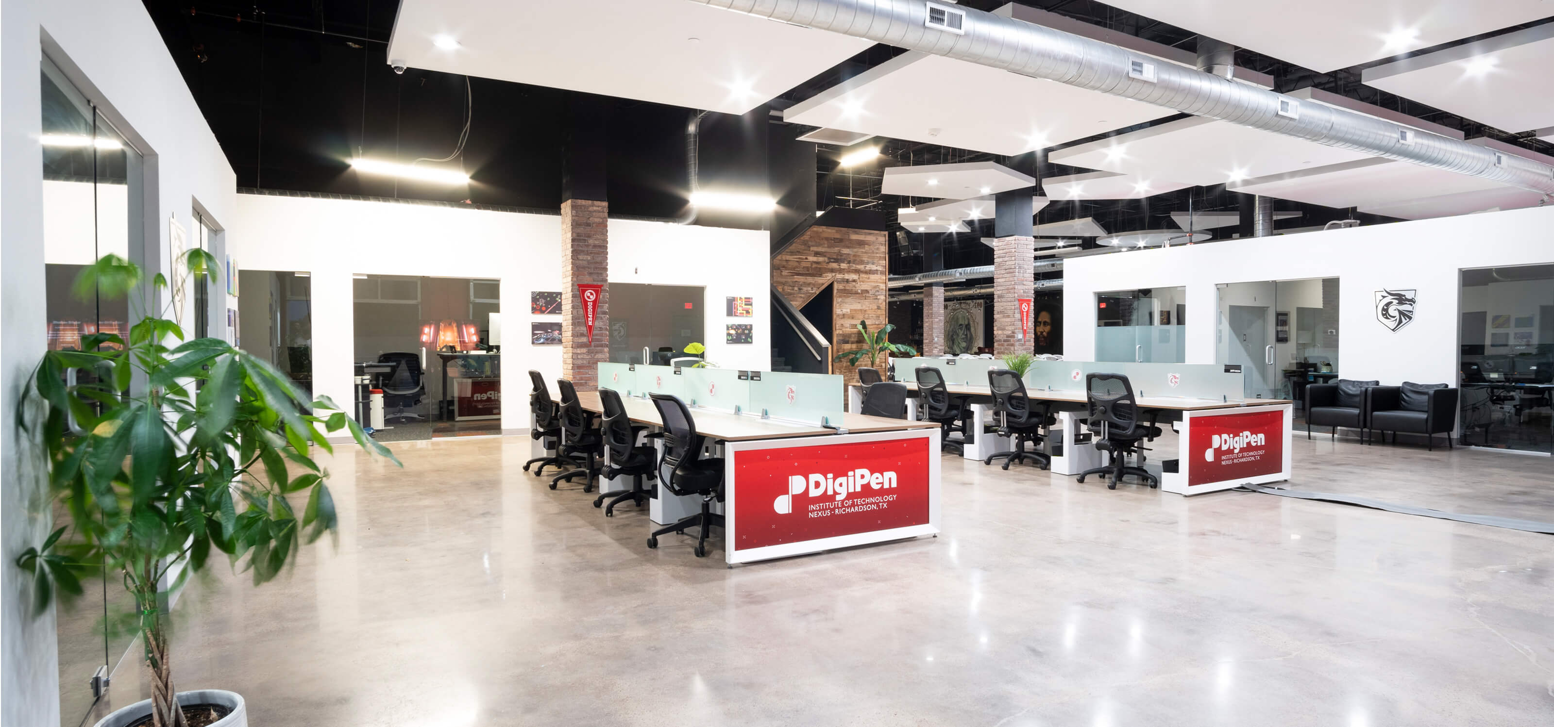 An open workspace area with multiple stations with the DigiPen logo on them